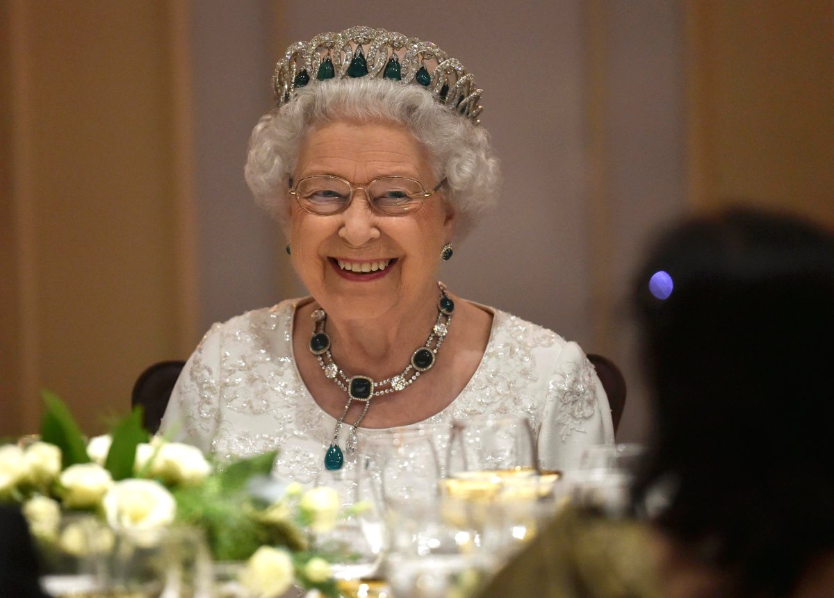 Queen Elizabeth II wearing an emerald and diamond tiara is smiles as she attends a dinner at the Corinthia Palace Hotel on November 27, 2015