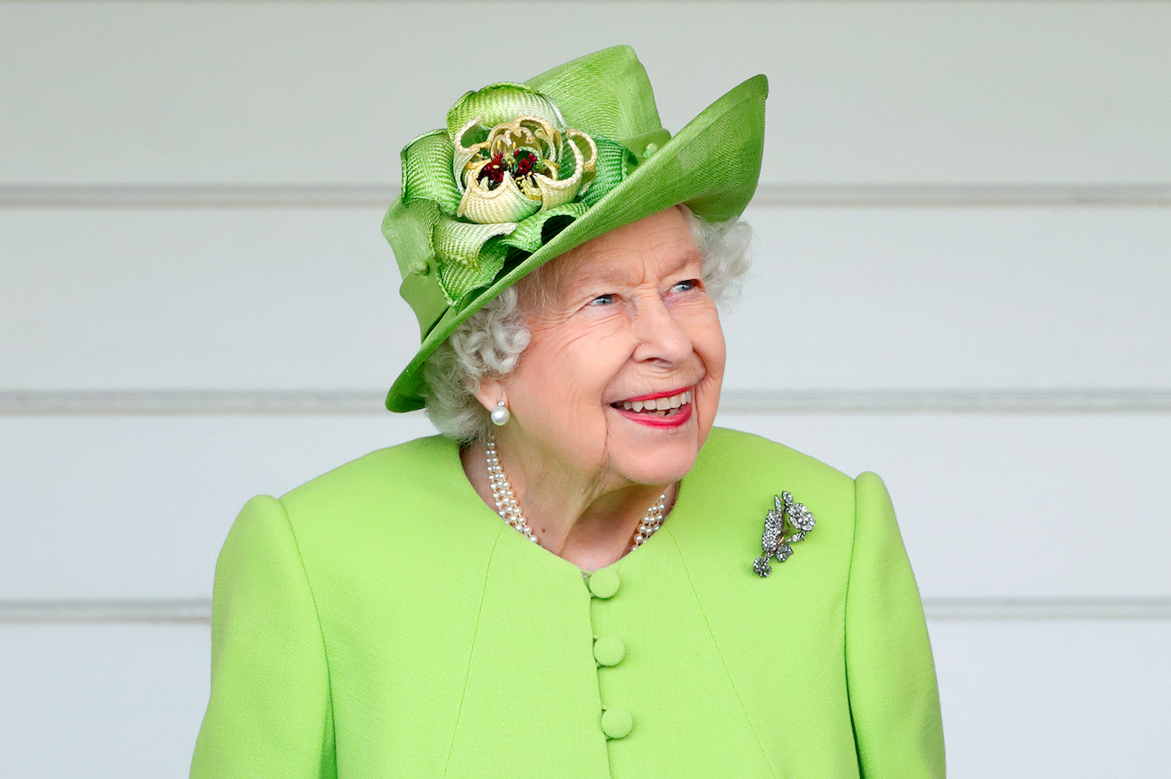 Queen Elizabeth wearing a light green outfit and smiling