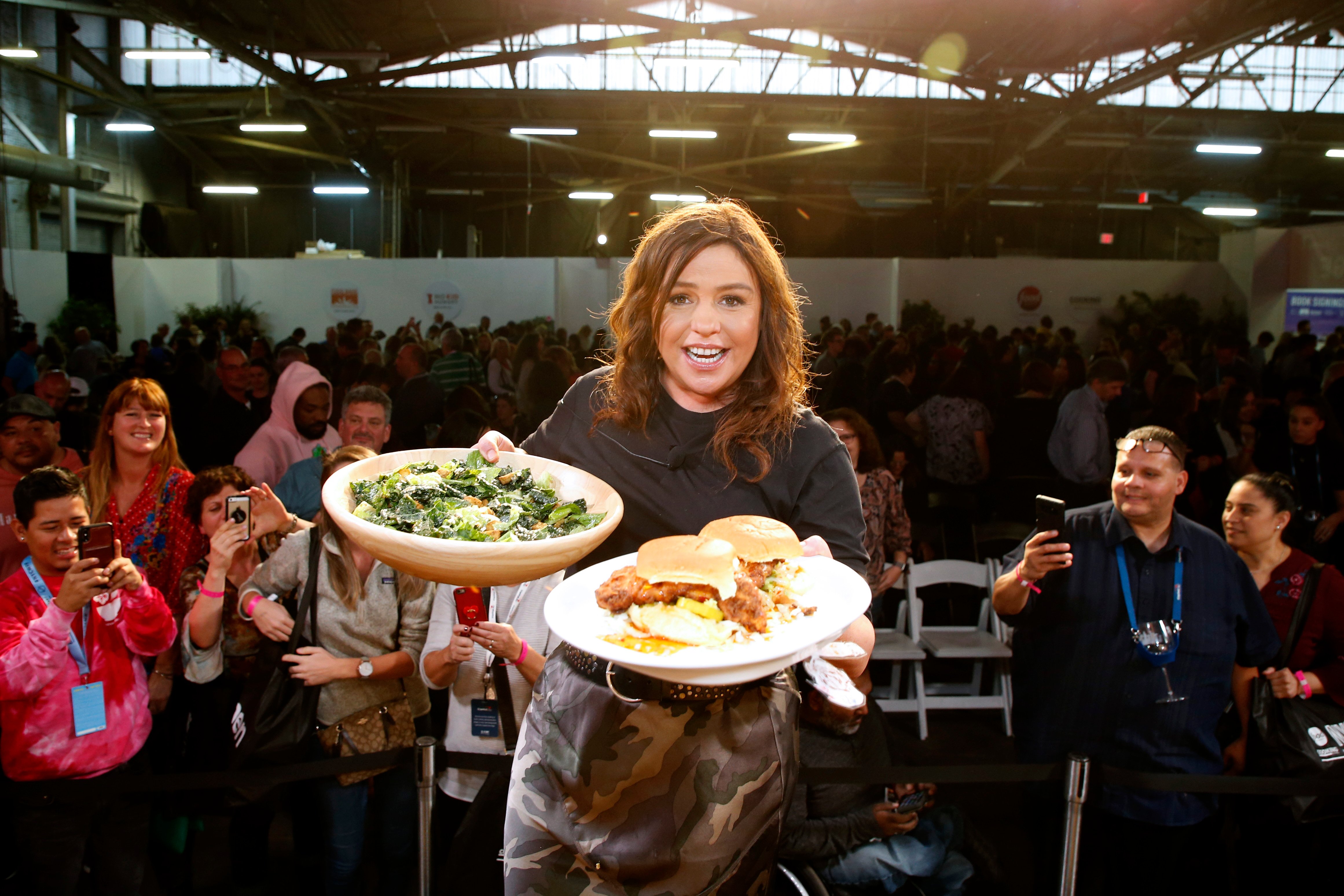 Rachael Ray holds a plate of food in each hand in this 2019 photo.