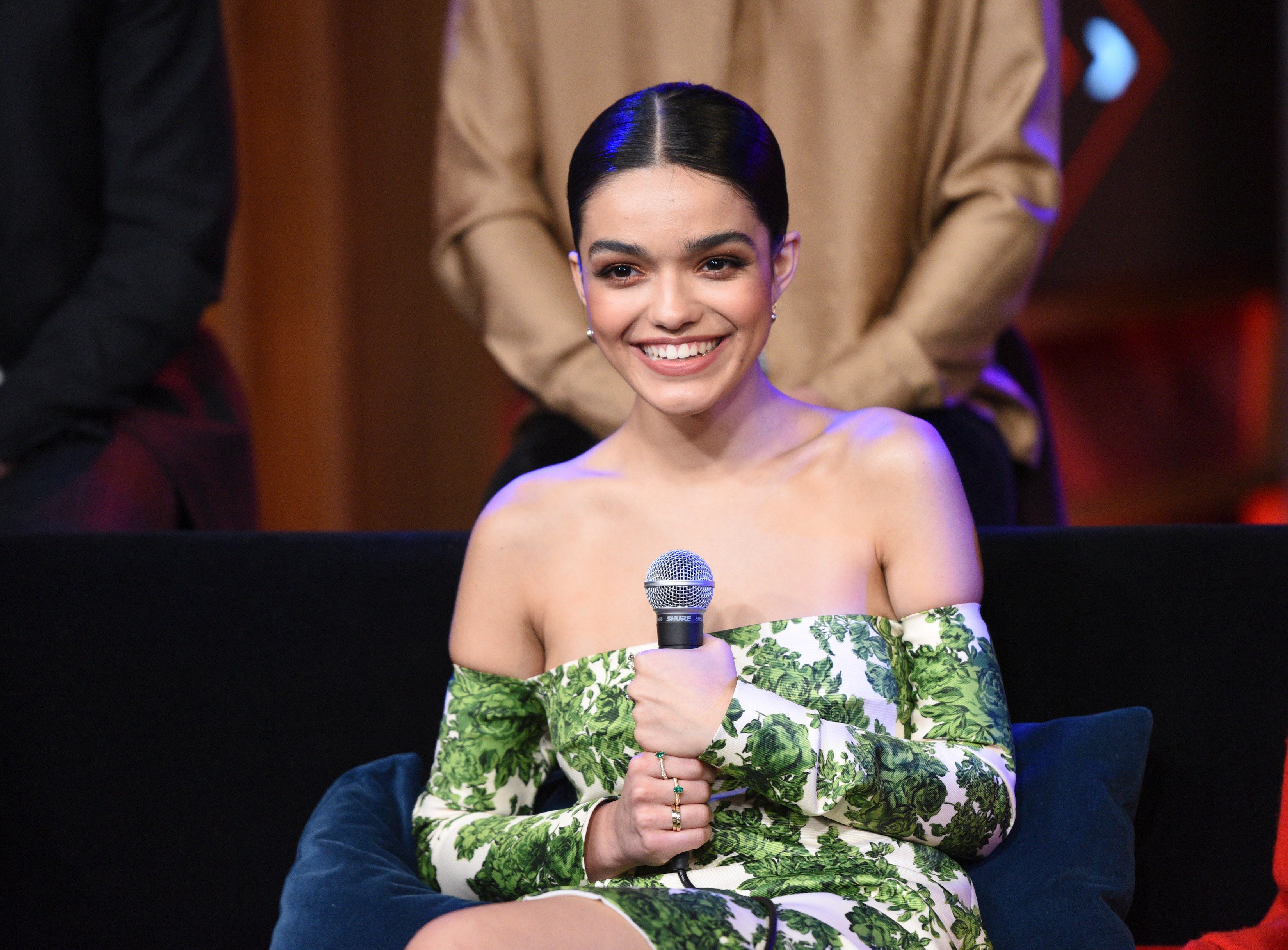 Rachel Zegler attends SiriusXM's Town Hall with the Cast of 'West Side Story' dressed in green holding microphone