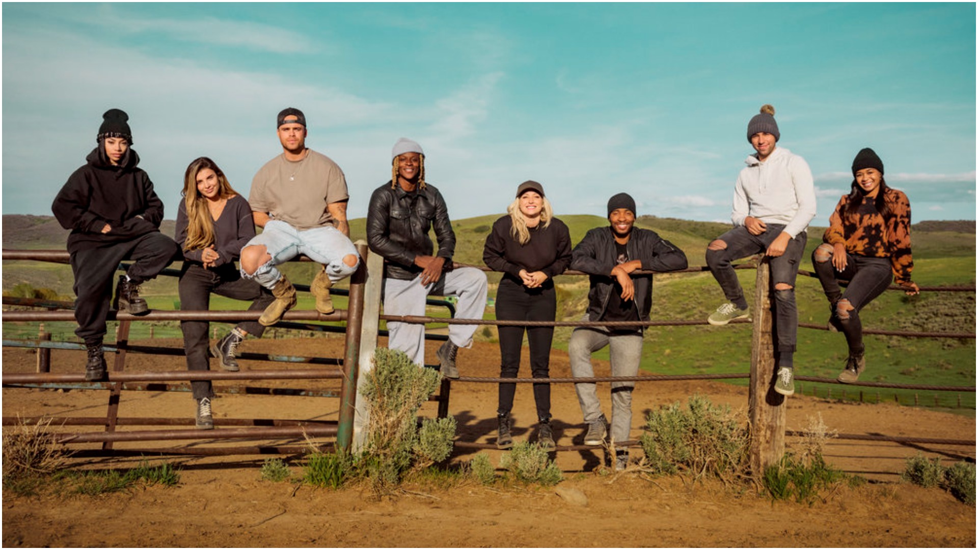 The cast of 'Relatively Famous: Ranch Rules' pose around a fence for a cast photo 