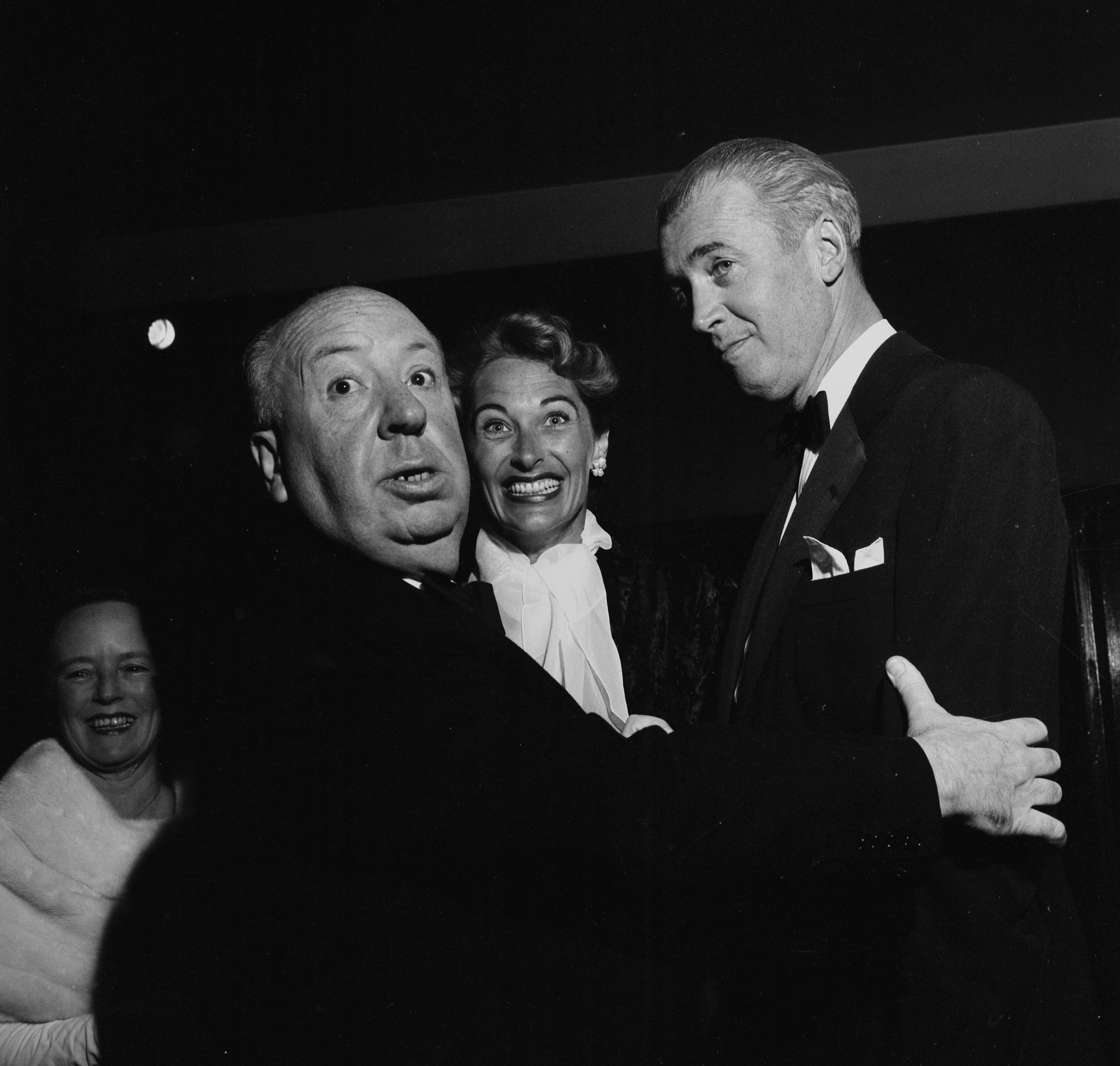 'Rear Window' Alfred Hitchcock and James Stewart in suits with Hitchcock holding Stewart's arm