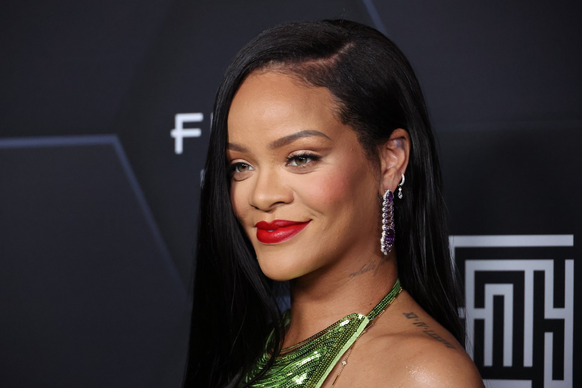 Rihanna smiles in front of a black background