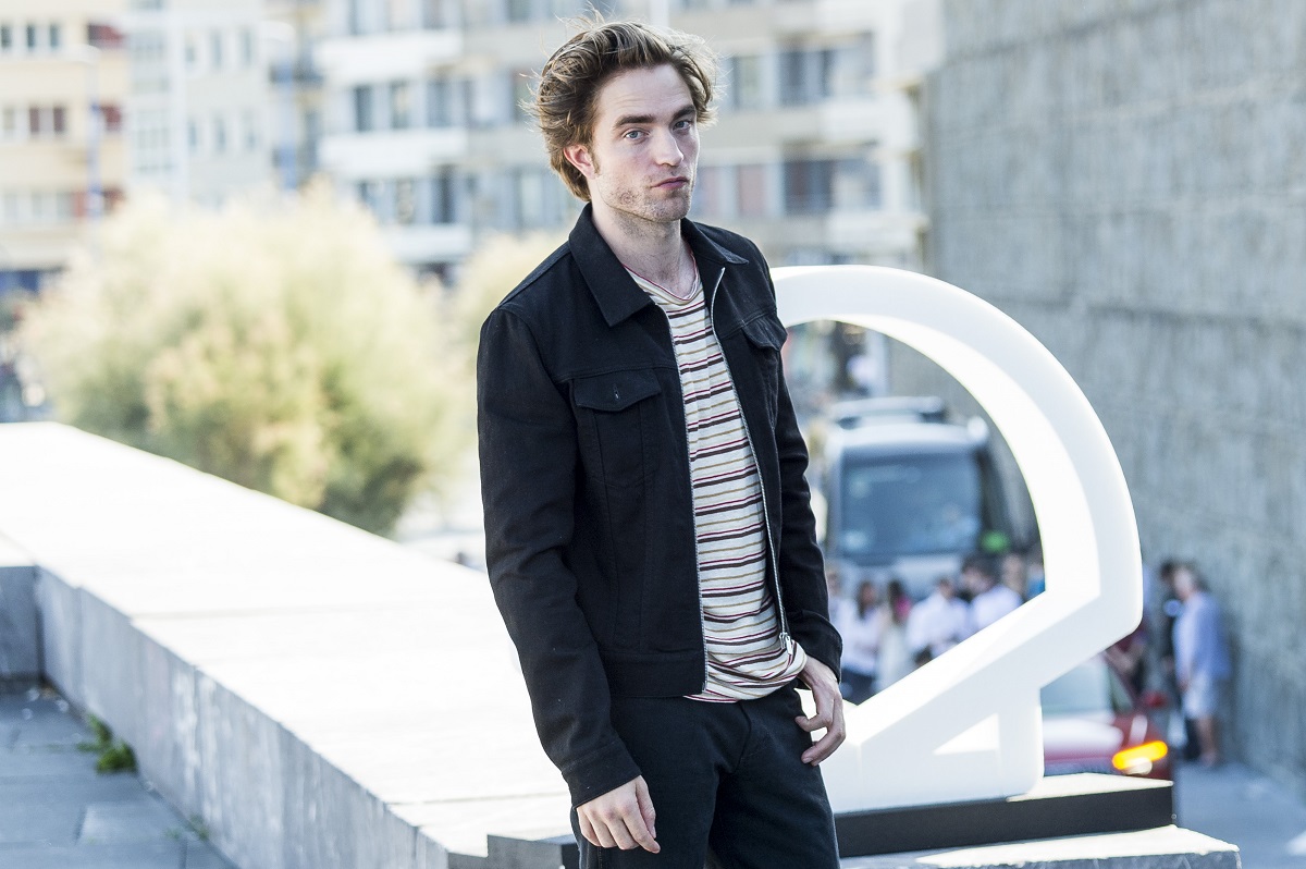 Robert Pattinson posing while wearing a jacket.