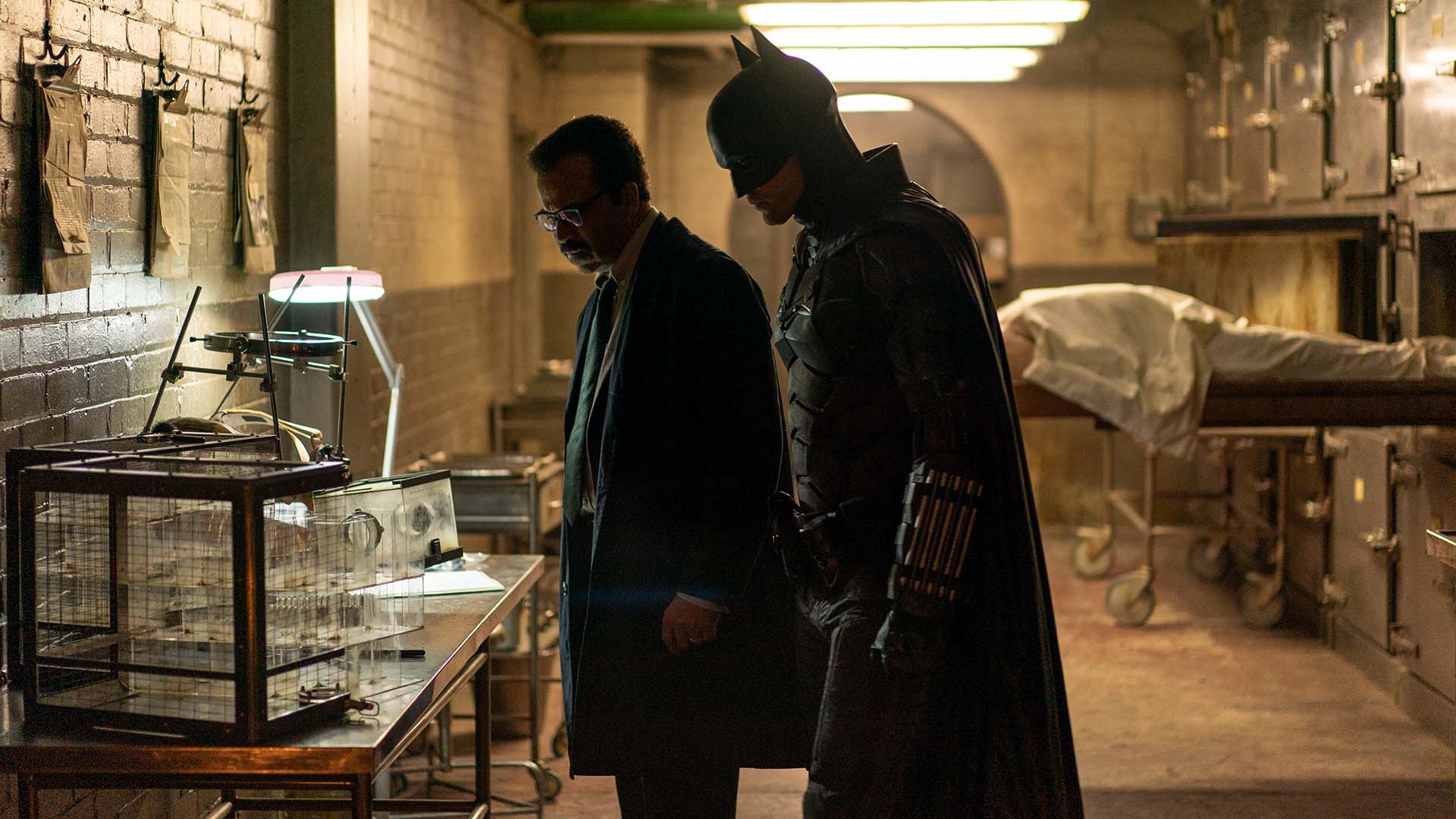 Robert Pattinson as Batman and Jeffrey Wright as Jim Gordon looking at something below in 'The Batman'