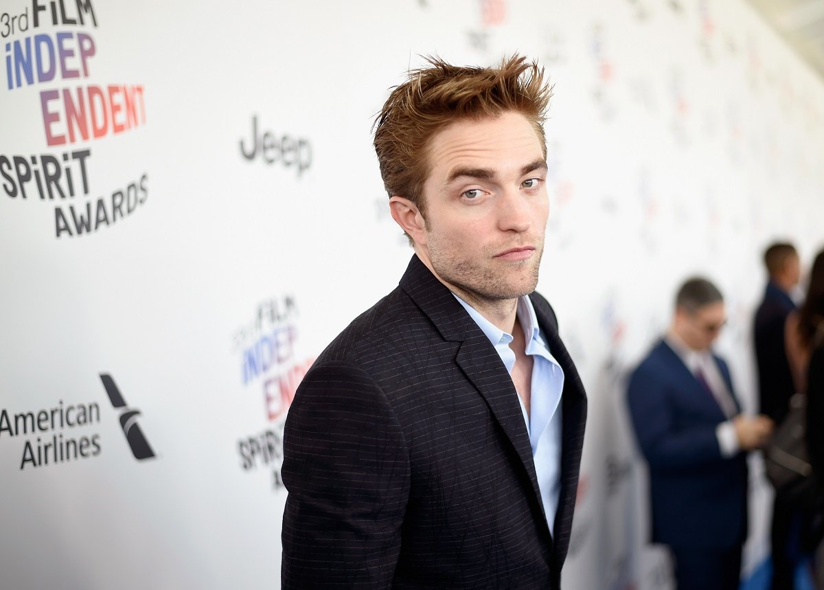 Robert Pattinson posing in a suit.