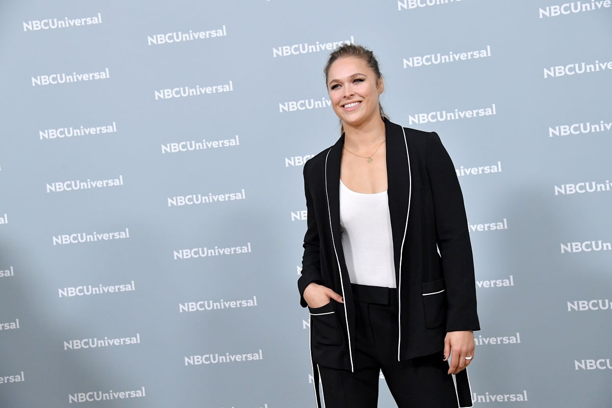Ronda Rousey smiling in a suit.
