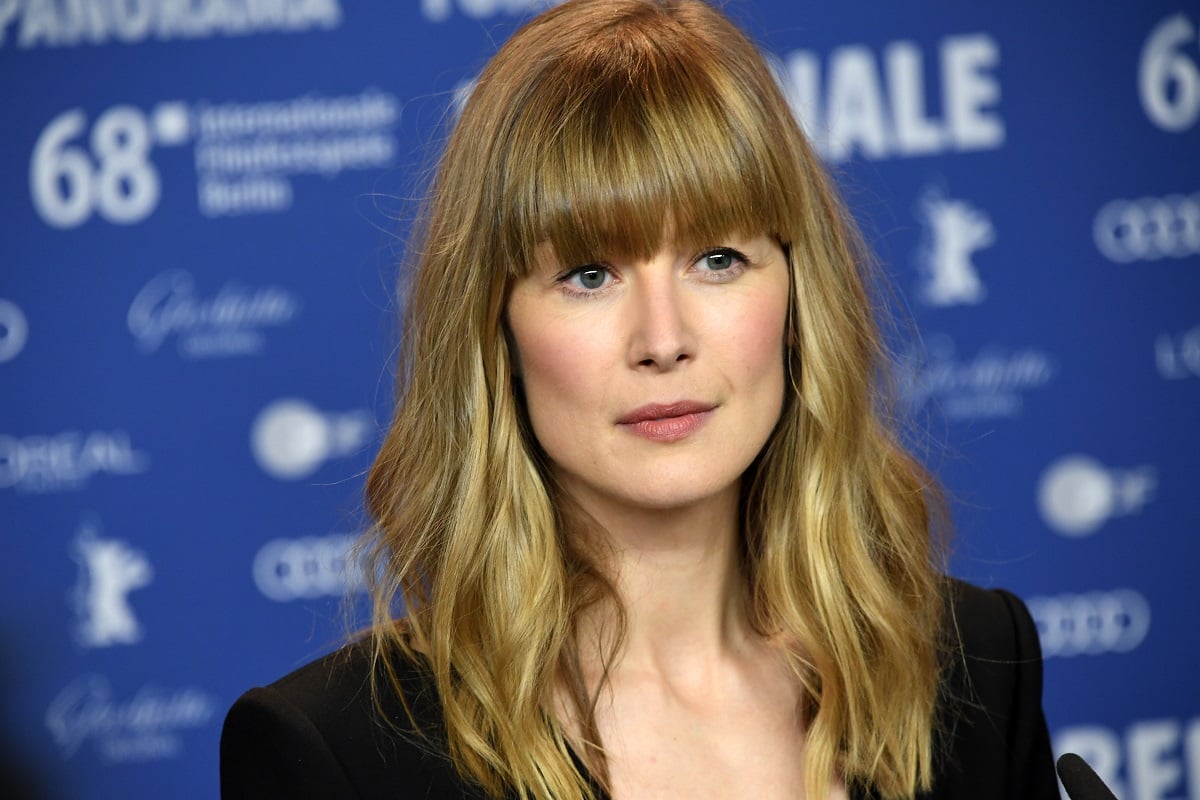 Rosamund Pike posing while wearing a black dress.