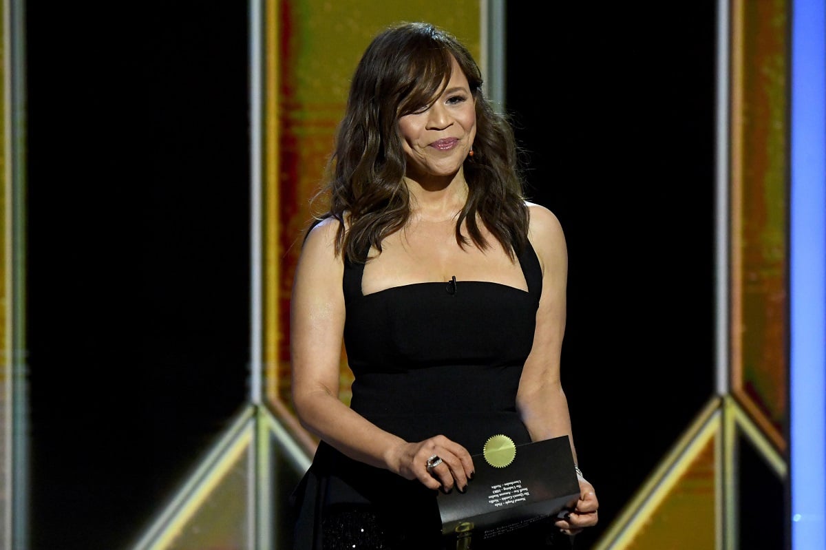 Rosie Perez smiling while wearing a black dress.