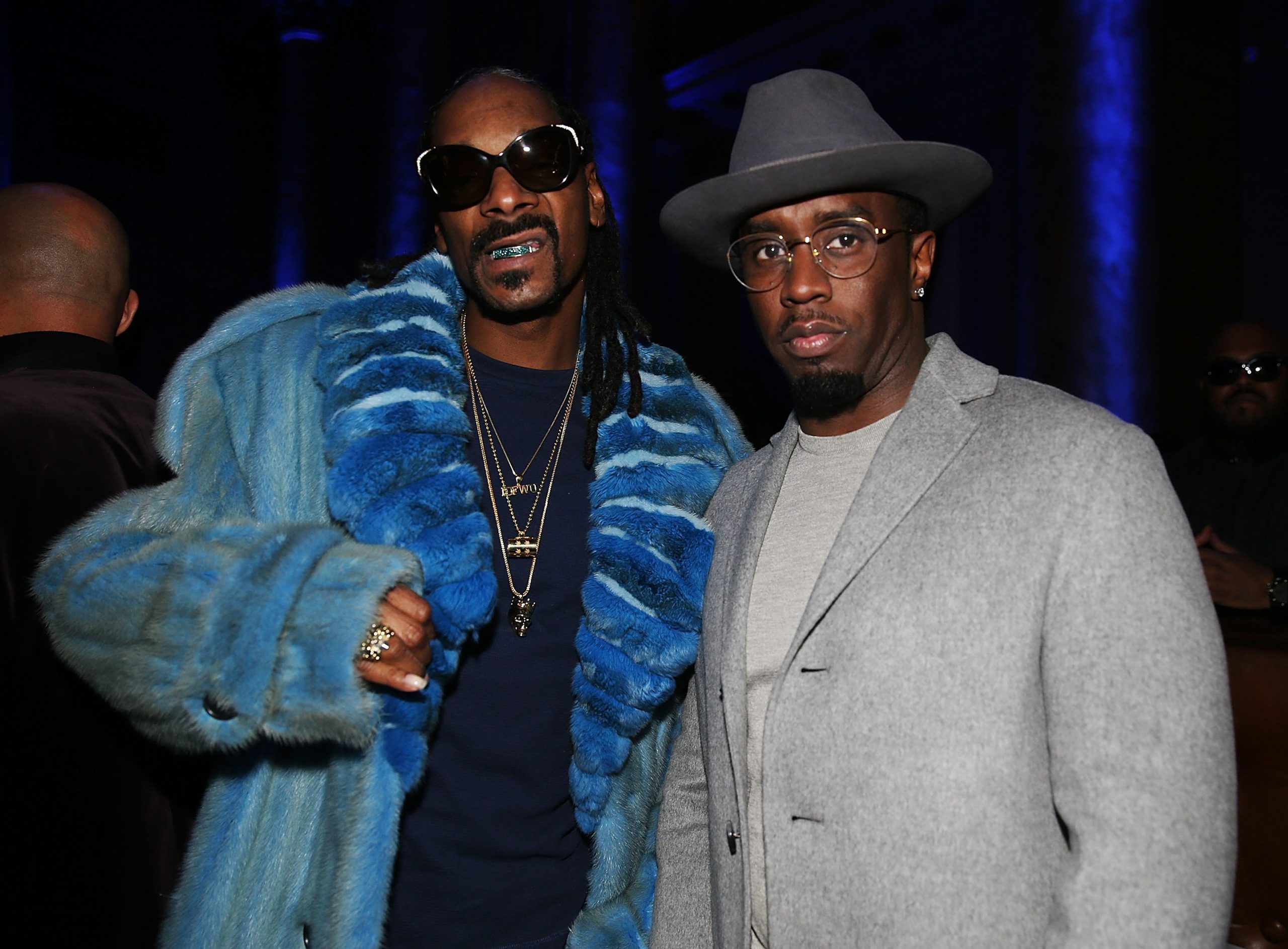 Snoop Dogg wearing blue and Diddy wearing a grey suit 
