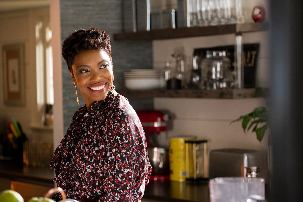 Heather Headley as Helen, smiling and standing in a kitchen in an episode of 'Sweet Magnolias' 