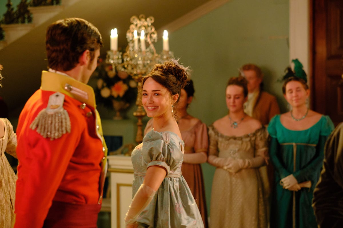 Charlotte dancing with a man in a red coat in 'Sanditon' Season 2