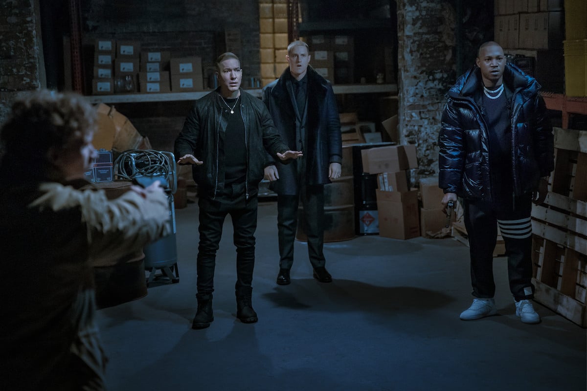 Joseph Sikora s Tommy Egan, Shane Harper as Vic Flynn and Kris D. Lofton as Jenard standing in a dark warehouse with guns pointed at themin 'Power Book IV: Force'