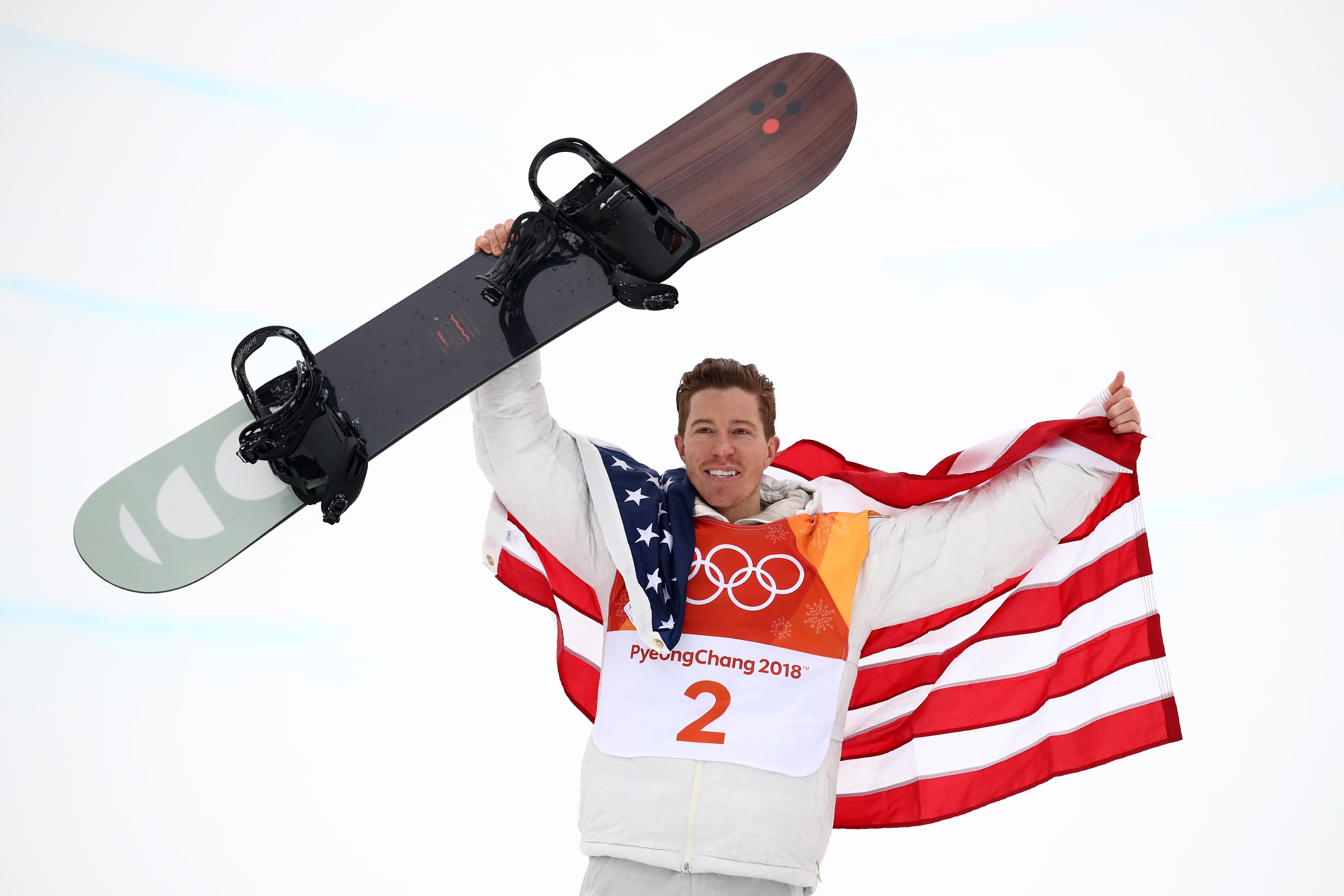 Shaun White poses with the American Flag and his snowboard at PyeongChang 2018 Winter Olympics