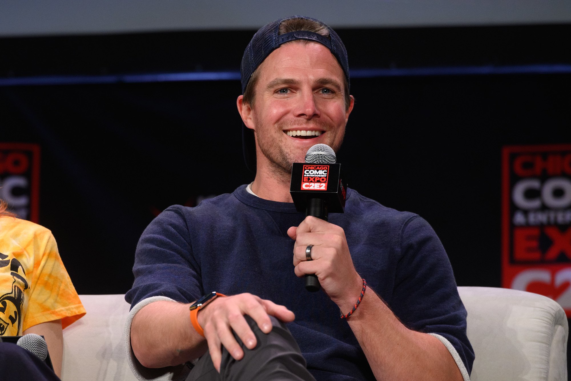 'Arrow' star Stephen Amell. He's sitting down and speaking into a microphone.