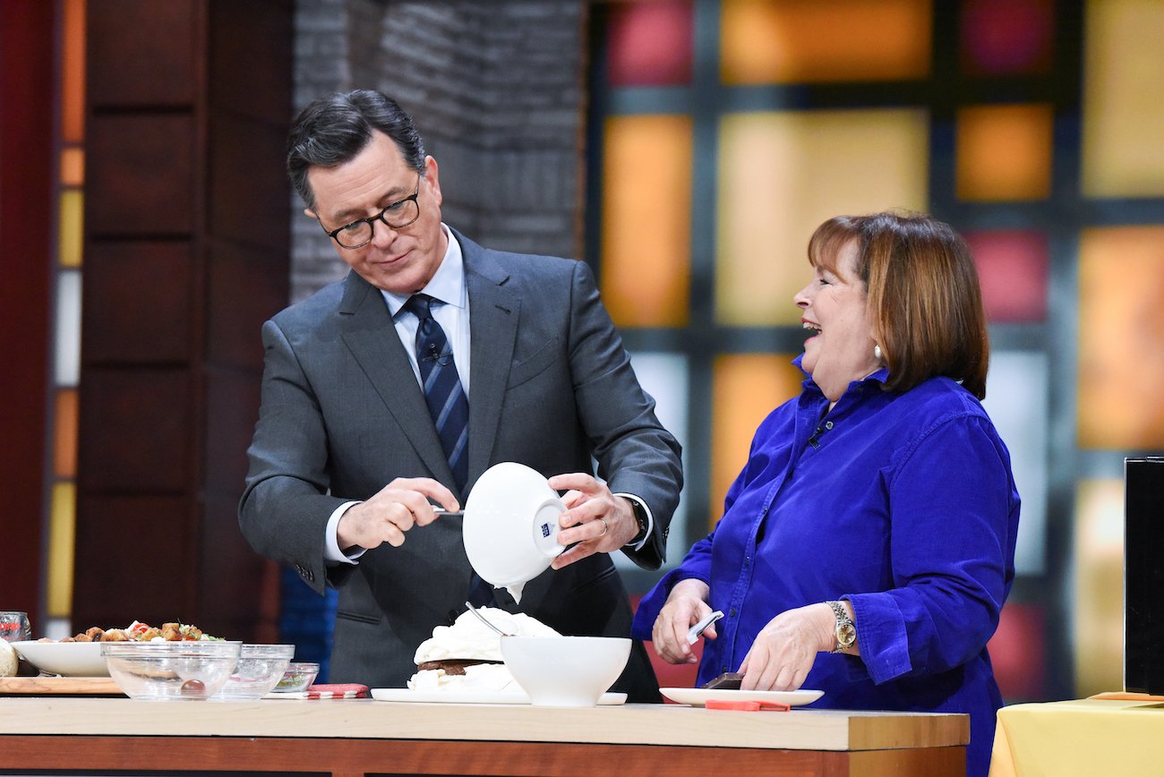 Ina Garten laughs as she watches Stephen Colbert pour out the contents of a bowl