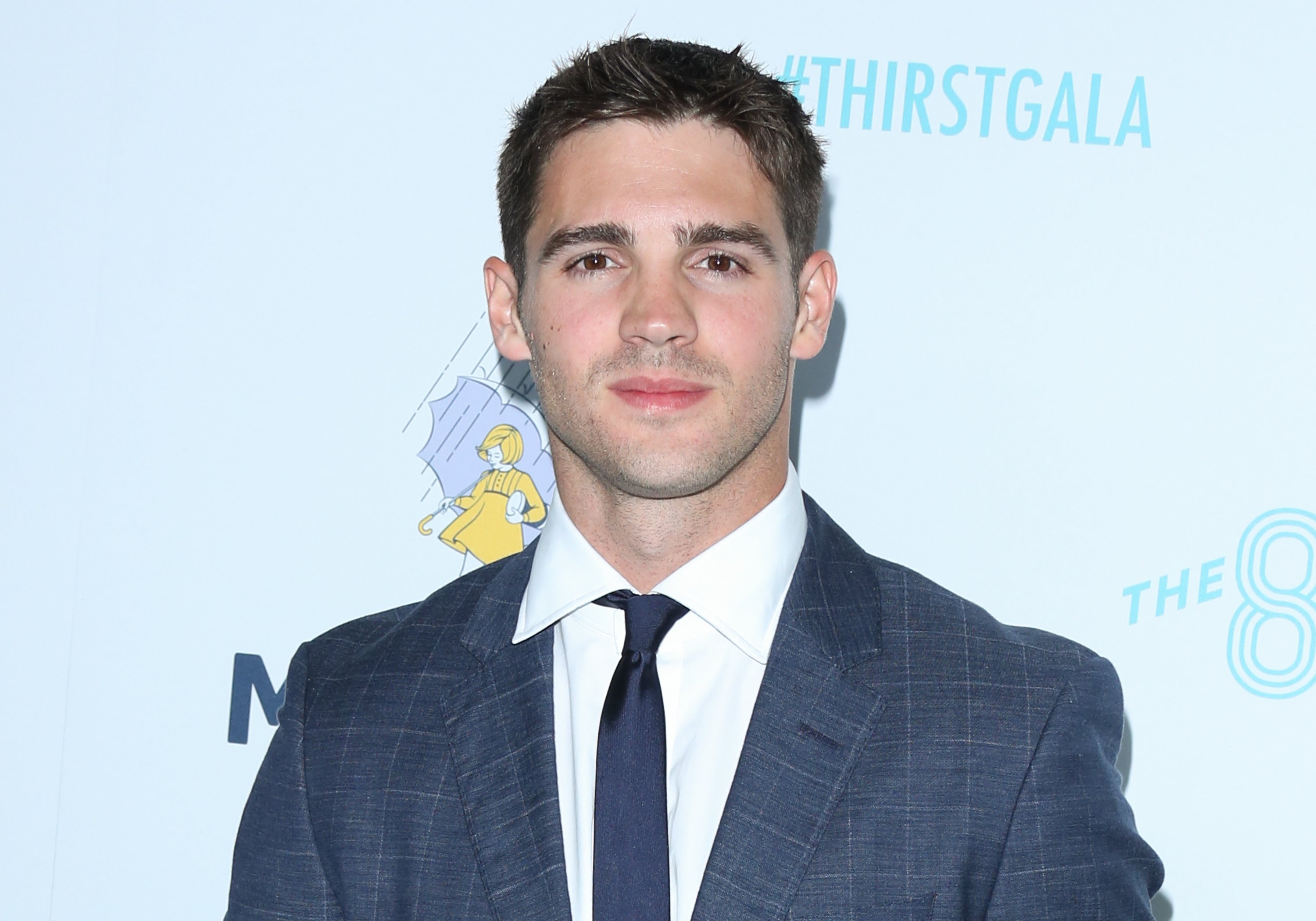 'The Vampire Diaries' star Steven R McQueen wears a dark gray suit over a white button-up shirt and black tie.