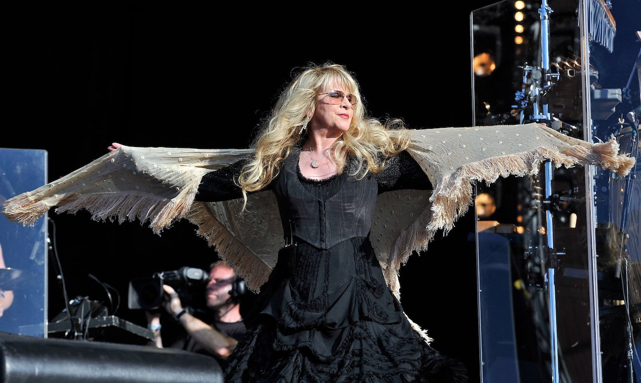 Stevie Nicks wearing a black dress and tan shawl while performing in London, 2011.