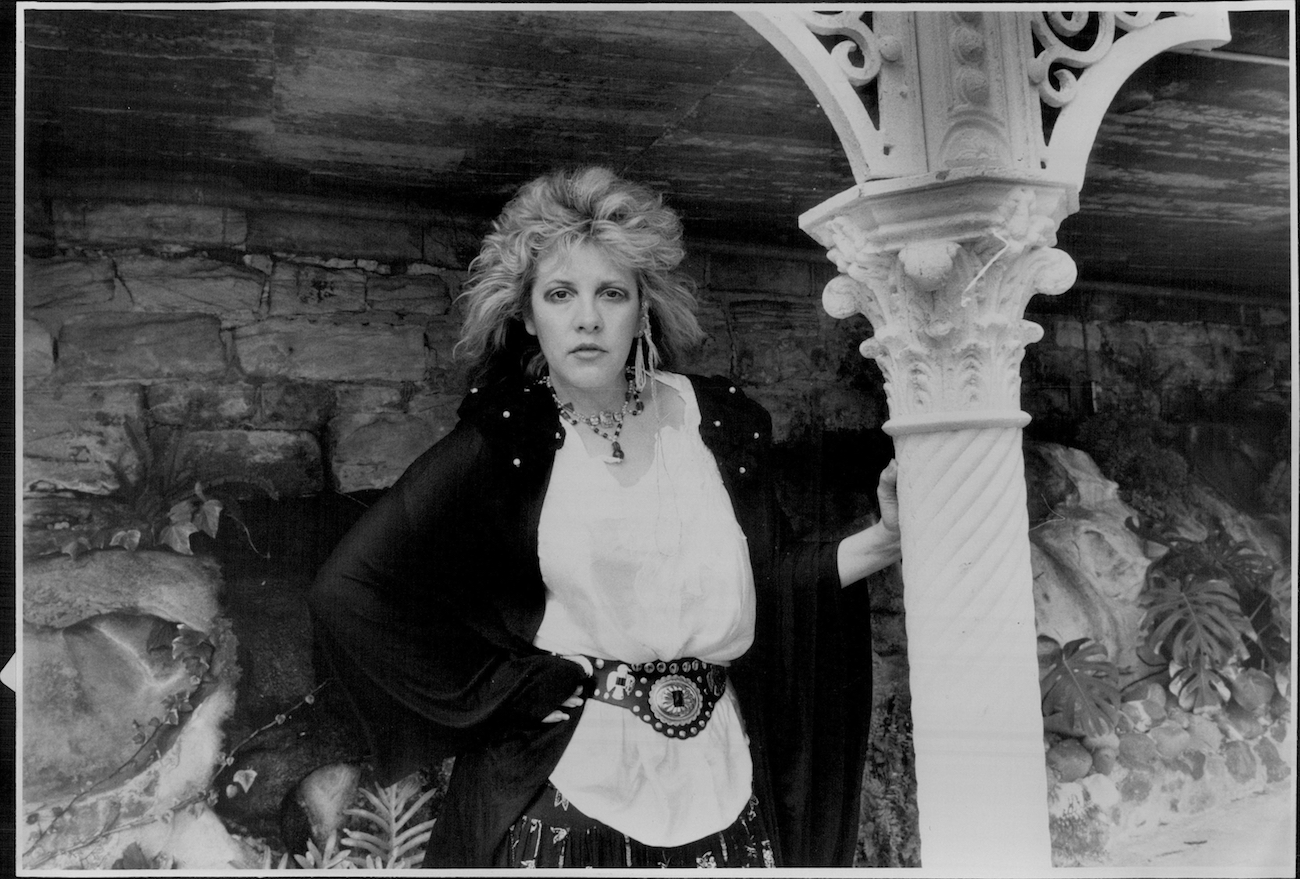 Stevie Nicks posing in black outside a building in 1986.