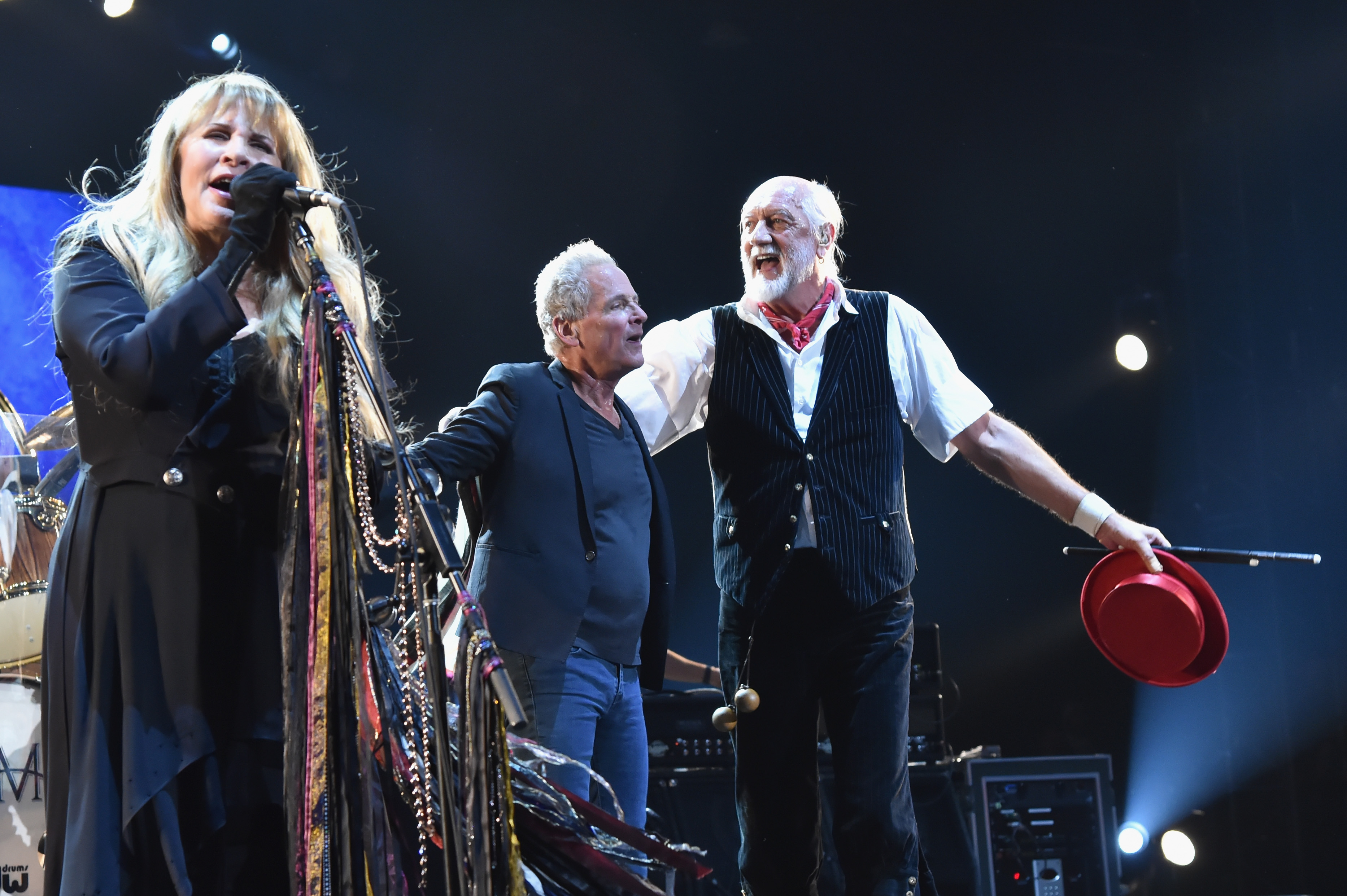 Stevie Nicks sings alongside Lindsey Buckingham and Mick Fleetwood onstage.