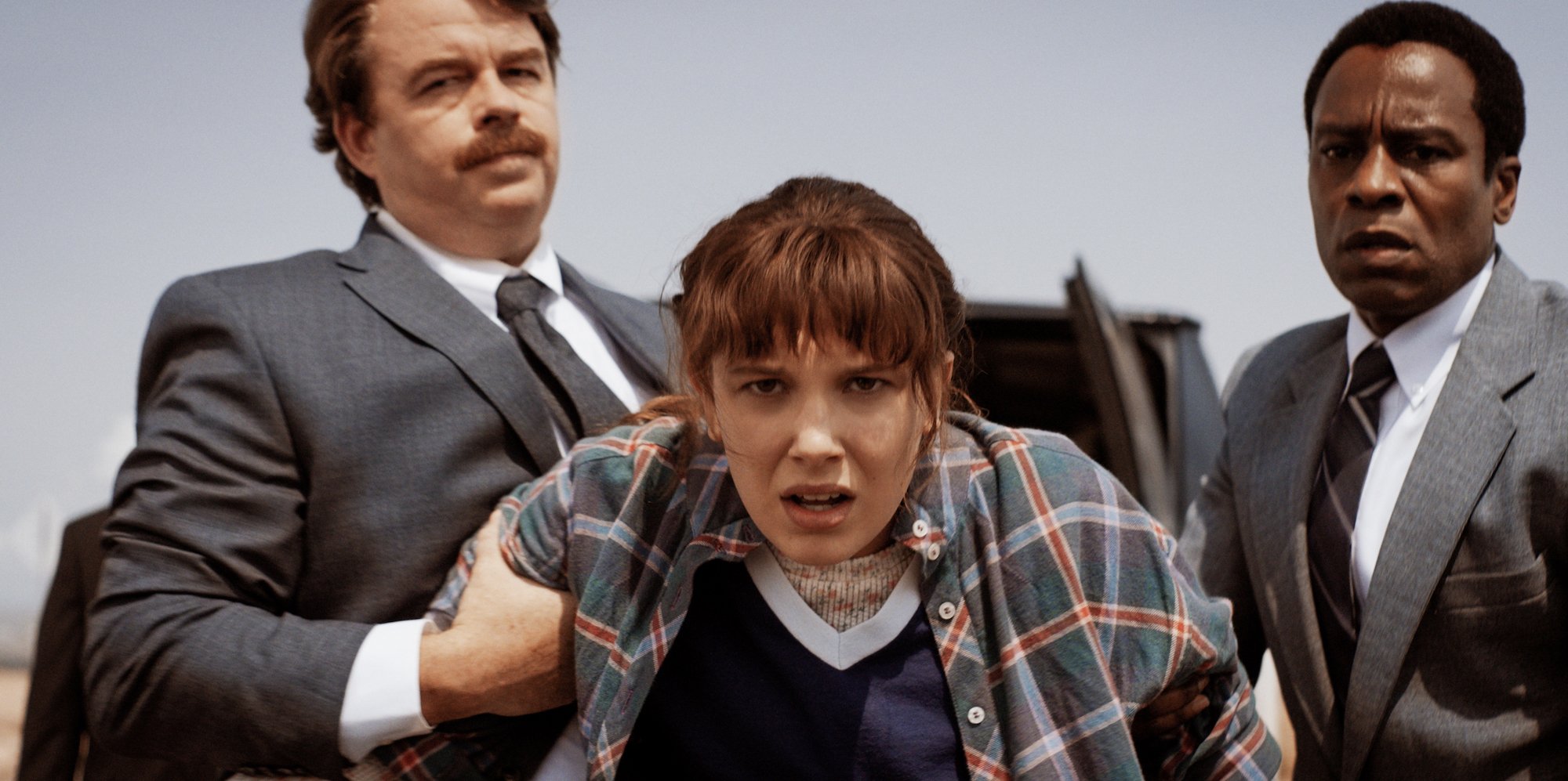'Stranger Things' Season 4 production still of Eleven being held back by two men. A 'Stranger Things' Season 4 time jump would help explain the kids' ages.