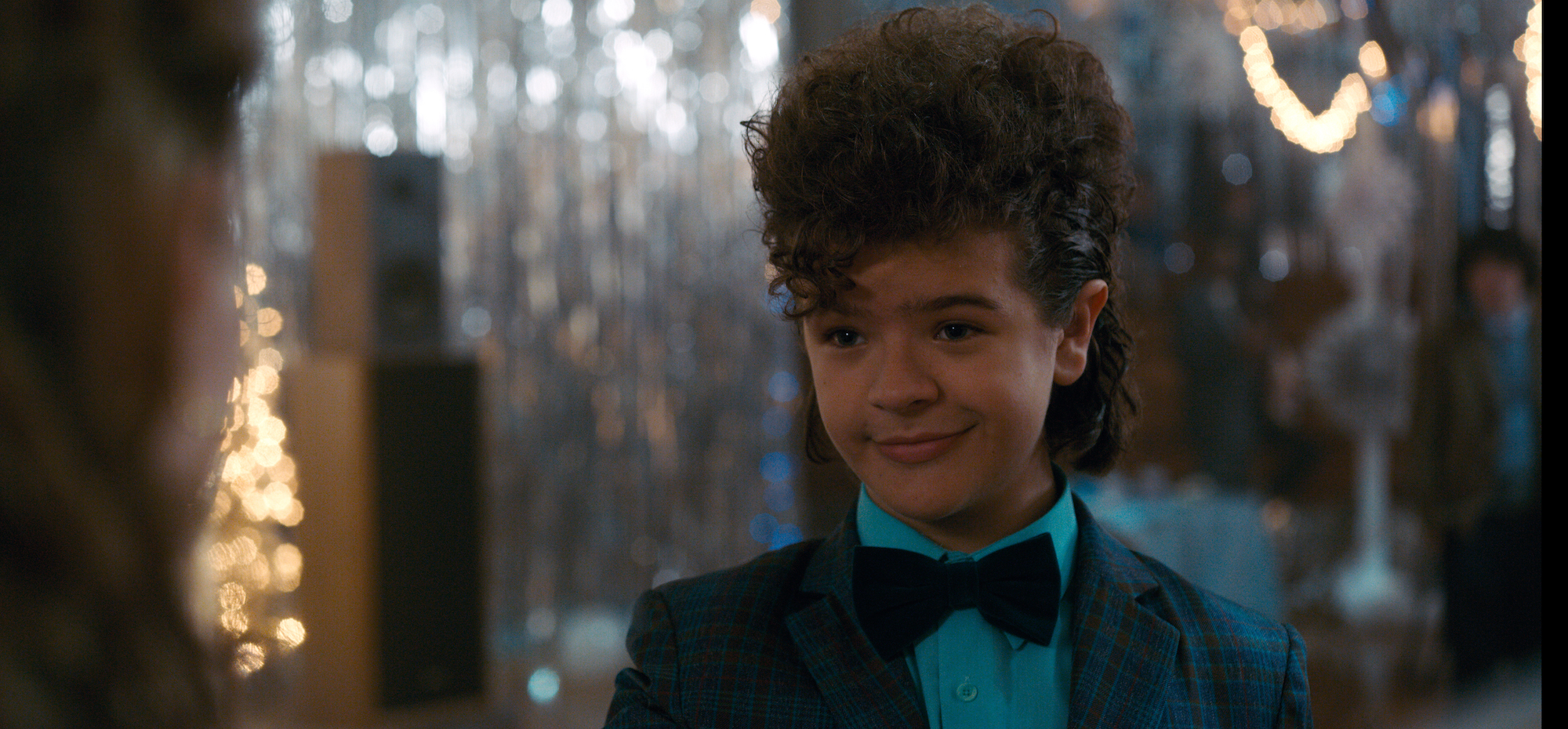 'Stranger Things' star Gaten Matarazzo wearing a blue suit in a production still from season 2