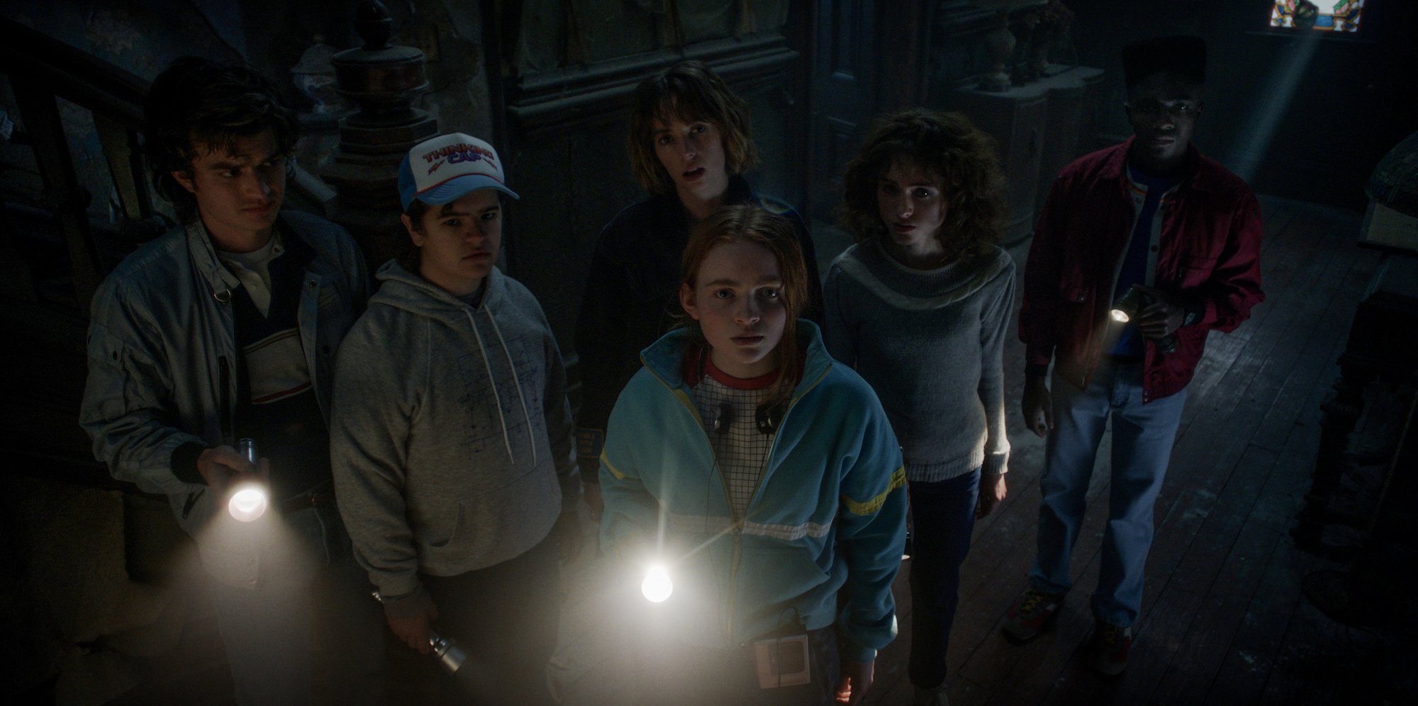 Stranger Things Season 4 production still of Max holding a flashlight in front of the rest of the group at the Creel House.
