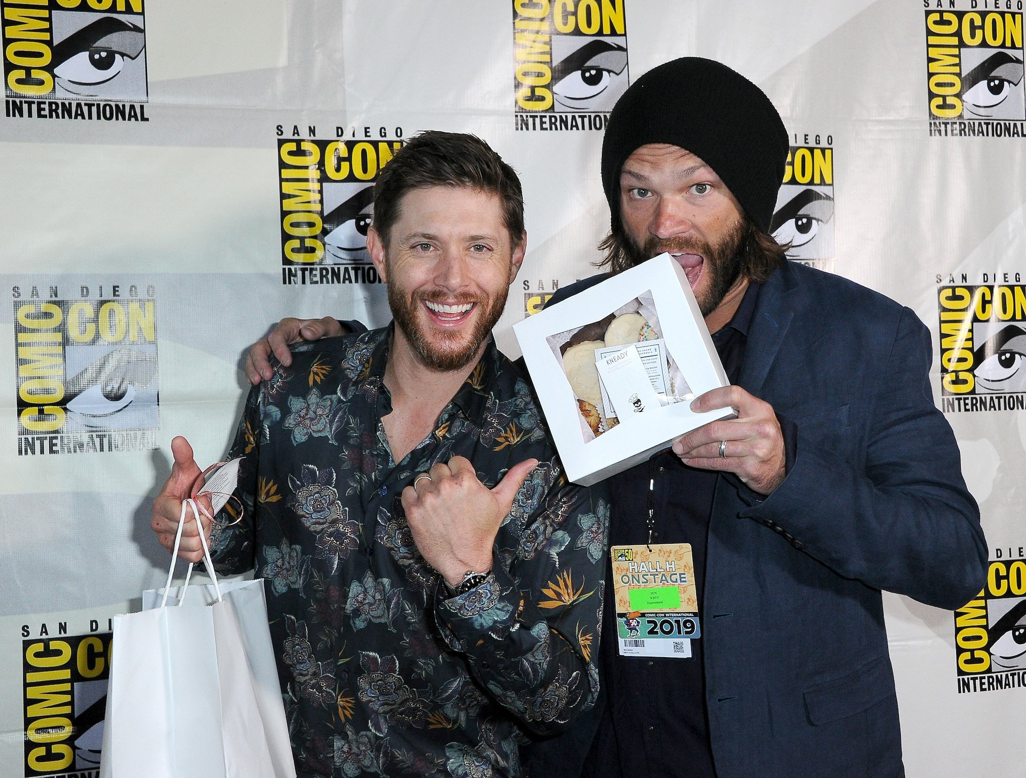'Supernatural' star Jensen Ackles holds a bag and Jared Padalecki bites a box at Comic-Con