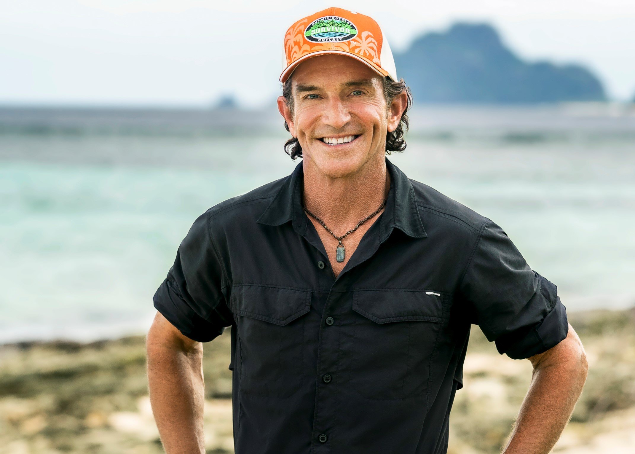 Jeff Probst, the host of 'Survivor' Season 42, which premieres on March 9, wears a black button-up shirt with rolled up sleeves above his elbows and an orange 'Survivor' hat.