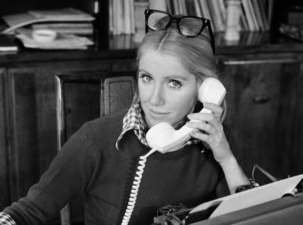 Suzanne Somers poses with a phone to her ear and glasses on her head