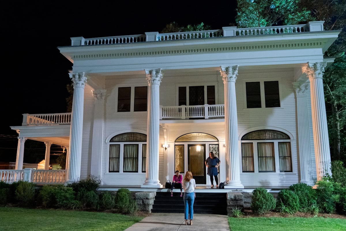 Helen and Dana Sue standing on the porch of the Corner Spa in Serenity, and Maddie standing on the front walk with back to camera, in 'Sweet Magnolias'