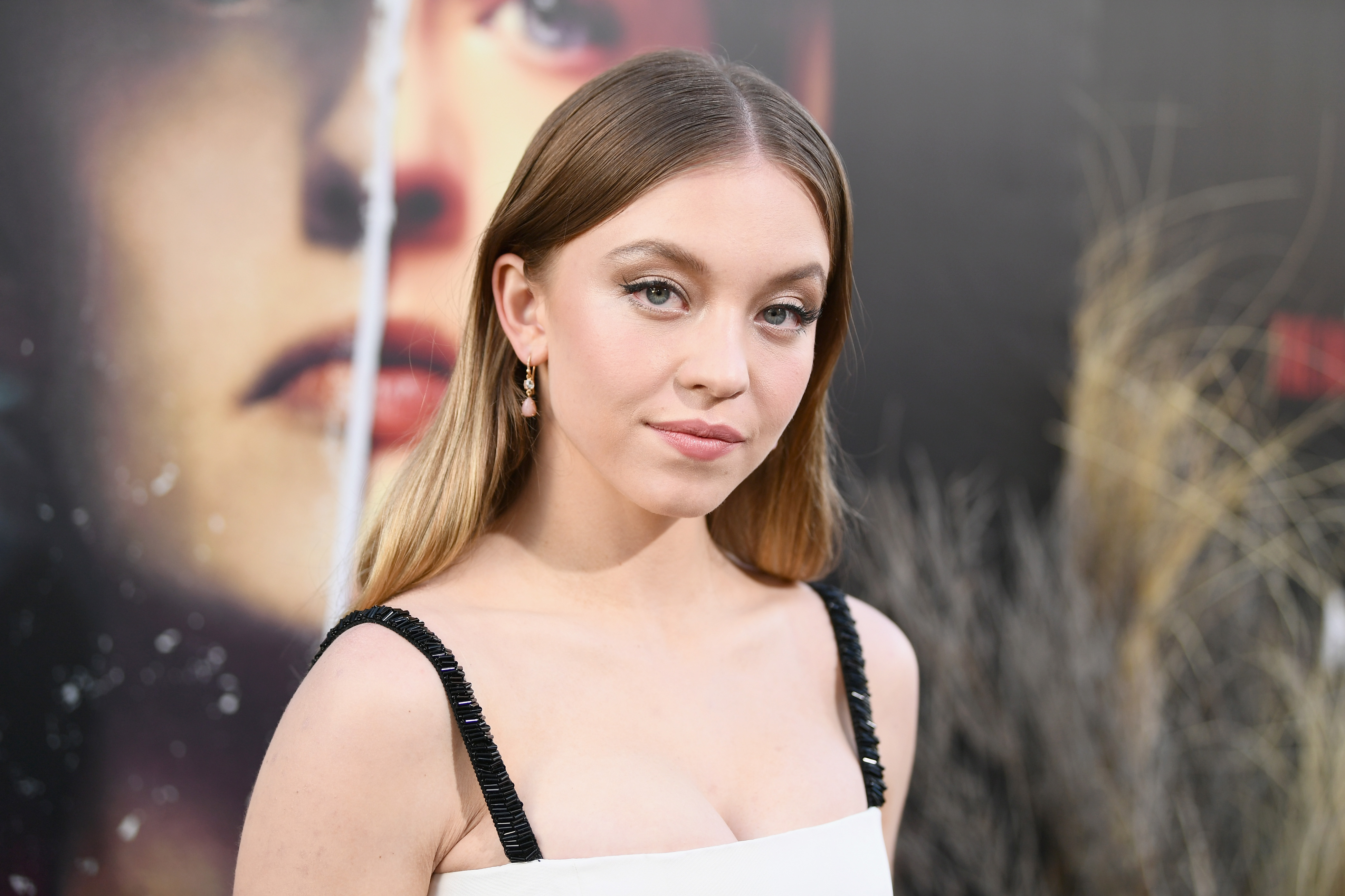 Sydney Sweeney attends the premiere of Hulu's The Handmaid's Tale Season 2 at TCL Chinese Theatre on April 19, 2018 in Hollywood, California. Sweeney wears a dress with black straps and dangly earrings.