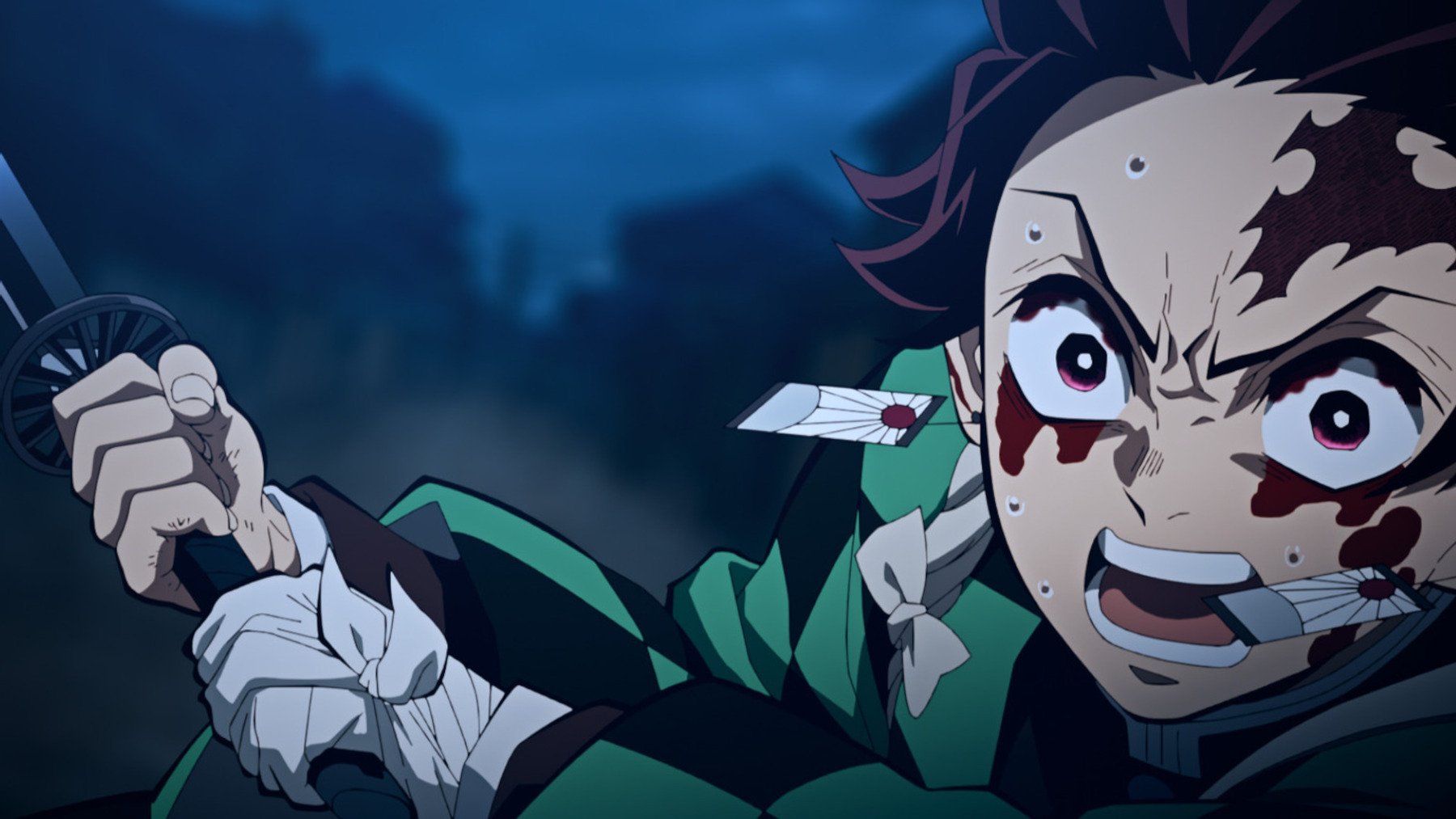 Tanjiro in 'Demon Slayer' Season 2's Entertainment District Arc. He's swinging his sword and covered in blood.