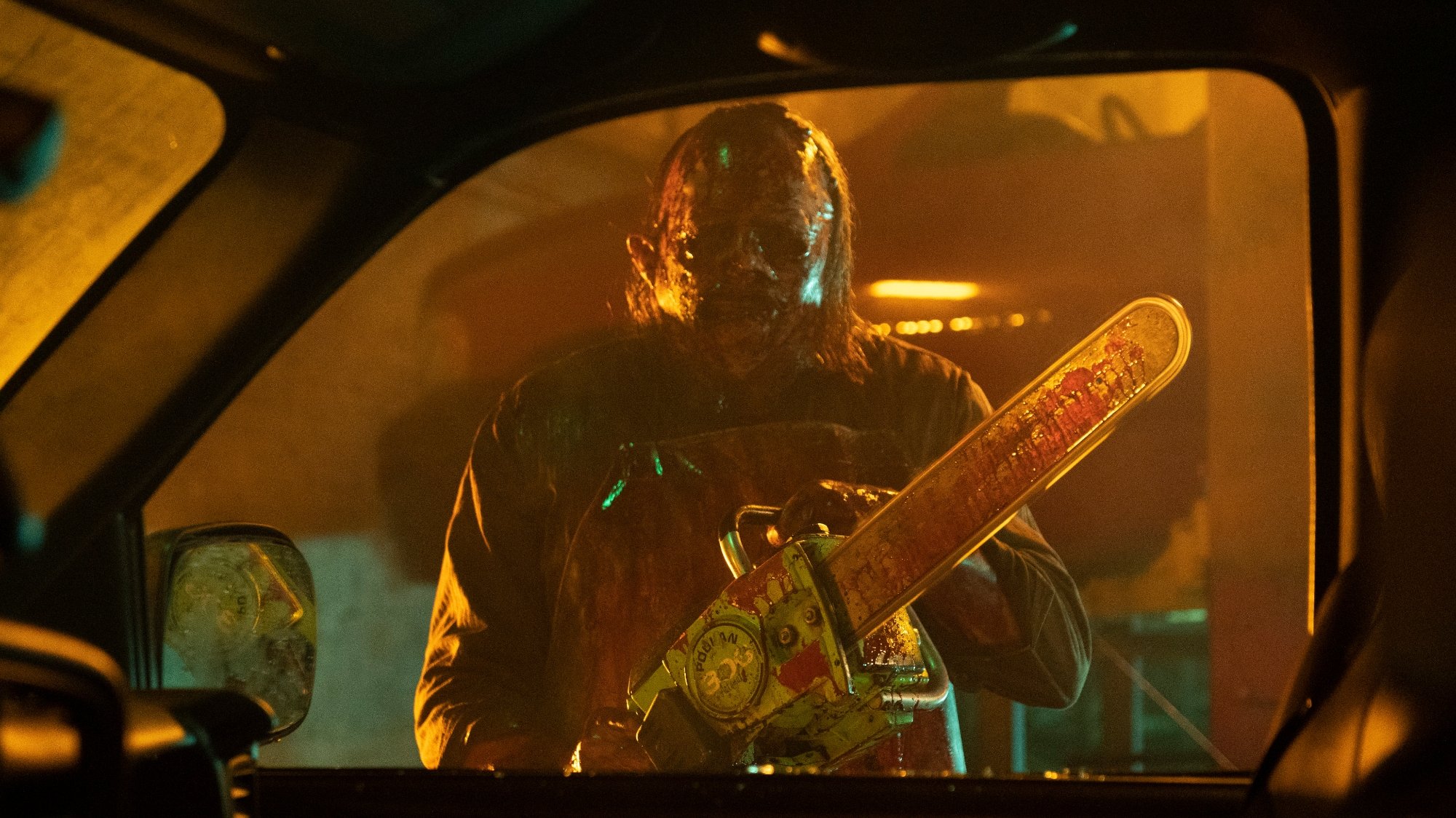 'Texas Chainsaw Massacre' review Mark Burnham as Leatherface holding a chainsaw in a car window