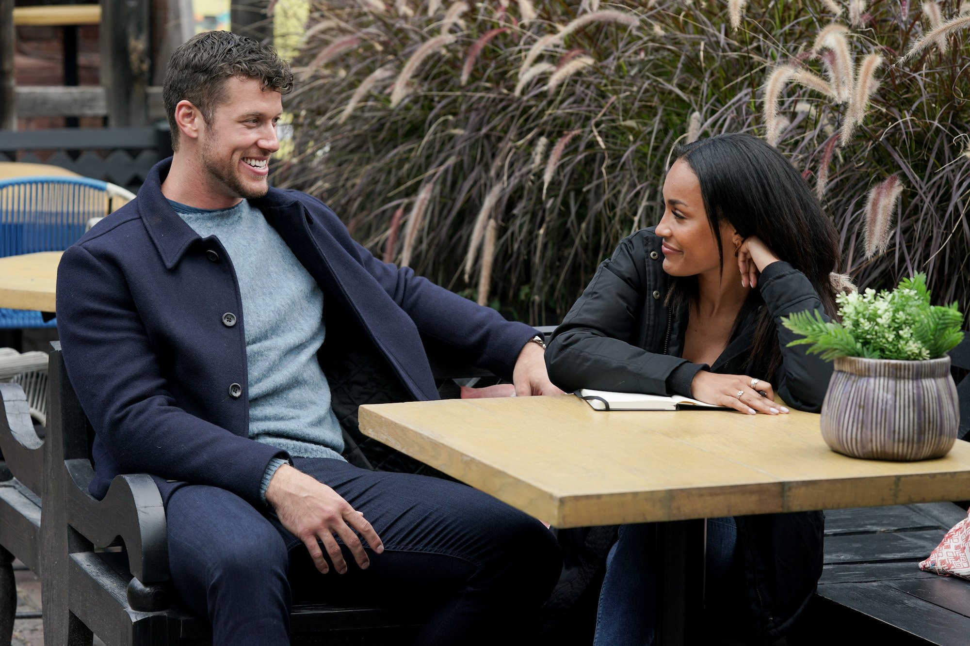 Clayton Echard and Serene Russell gaze at each other across a table. Is 'The Bachelor' on tonight, Feb. 28, 2022? Keep reading to find out.