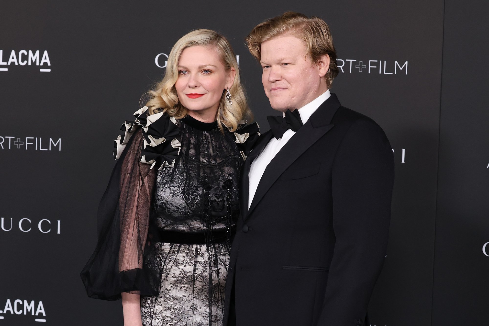 'The Power of the Dog' actors Kirsten Dunst and Jesse Plemons Oscars 2022 nominees standing in front of LACMA step and repeat