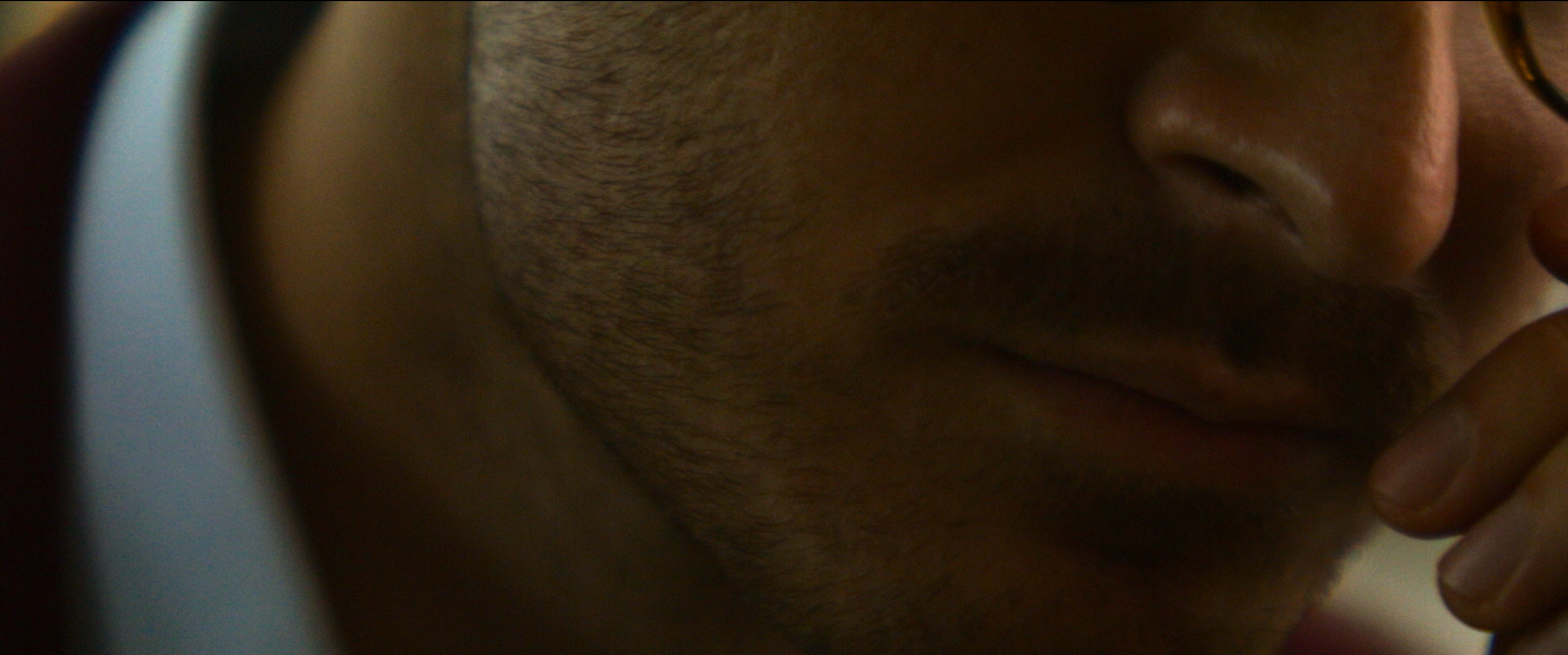 Image of the lower part of a man's face talking on the phone from Netflix's 'The Tinder Swindler'