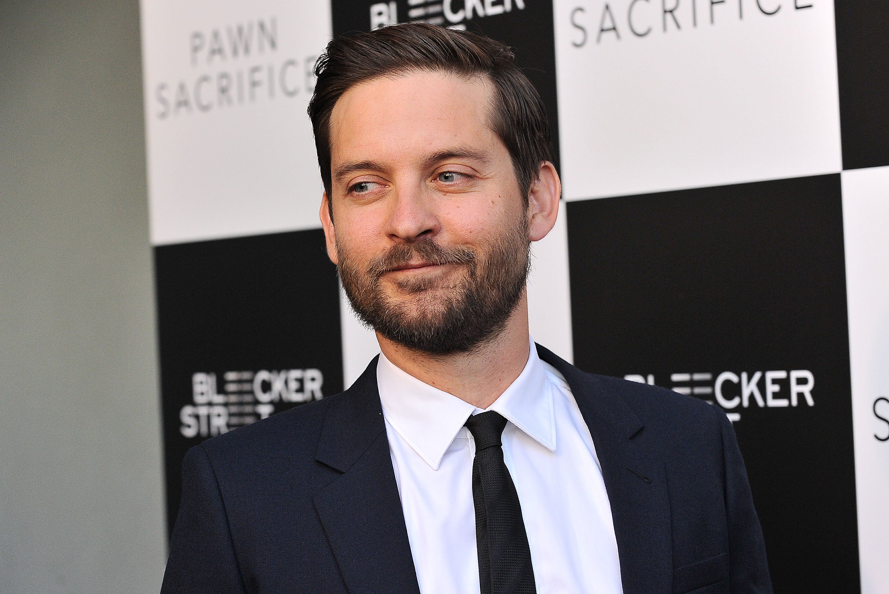 'Spider-Man: No Way Home' star Tobey Maguire wears a black suit over a white button-up shirt and black tie.