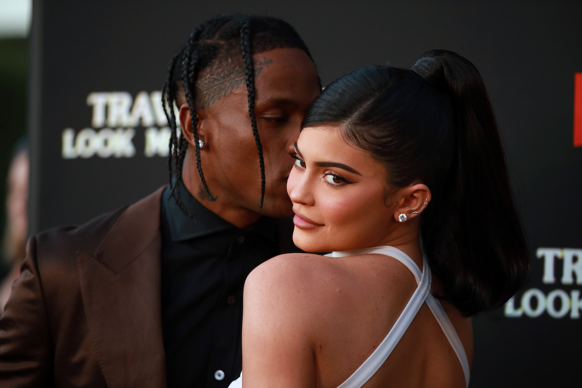 Travis Scott kisses Kylie Jenner's cheek at an event.