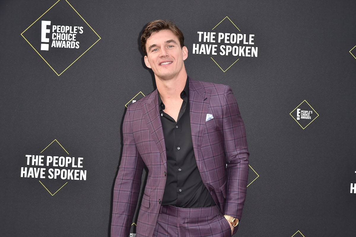 Tyler Cameron smiling in front of a black background