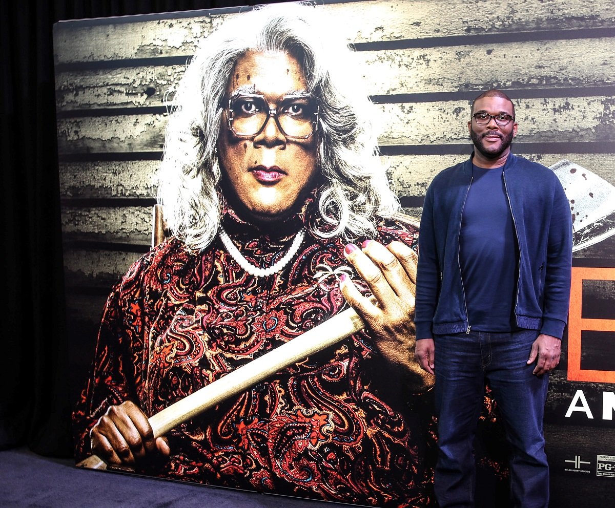 Tyler Perry on the red carpet next to poster of Madea at the screening of Boo! A Madea Halloween