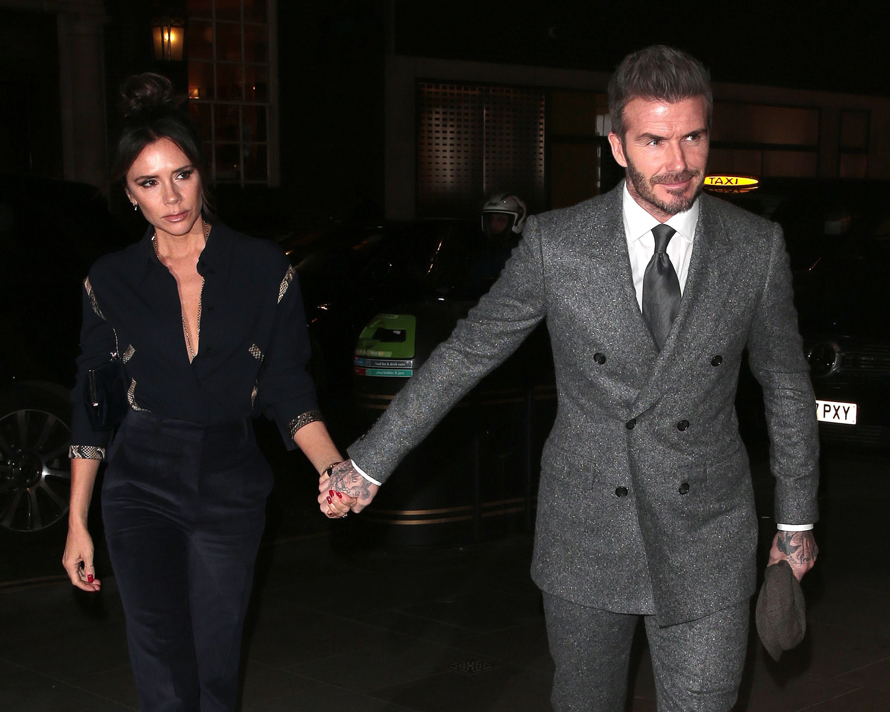 Victoria Beckham and David Beckham holding hands as they attend GQ Dinner