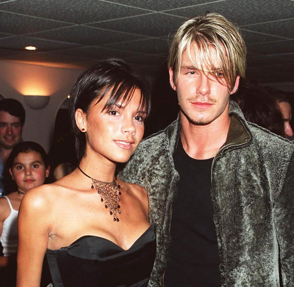 Victoria and David Beckham pose for a photo together backstage after a Whitney Houston concert in 1999