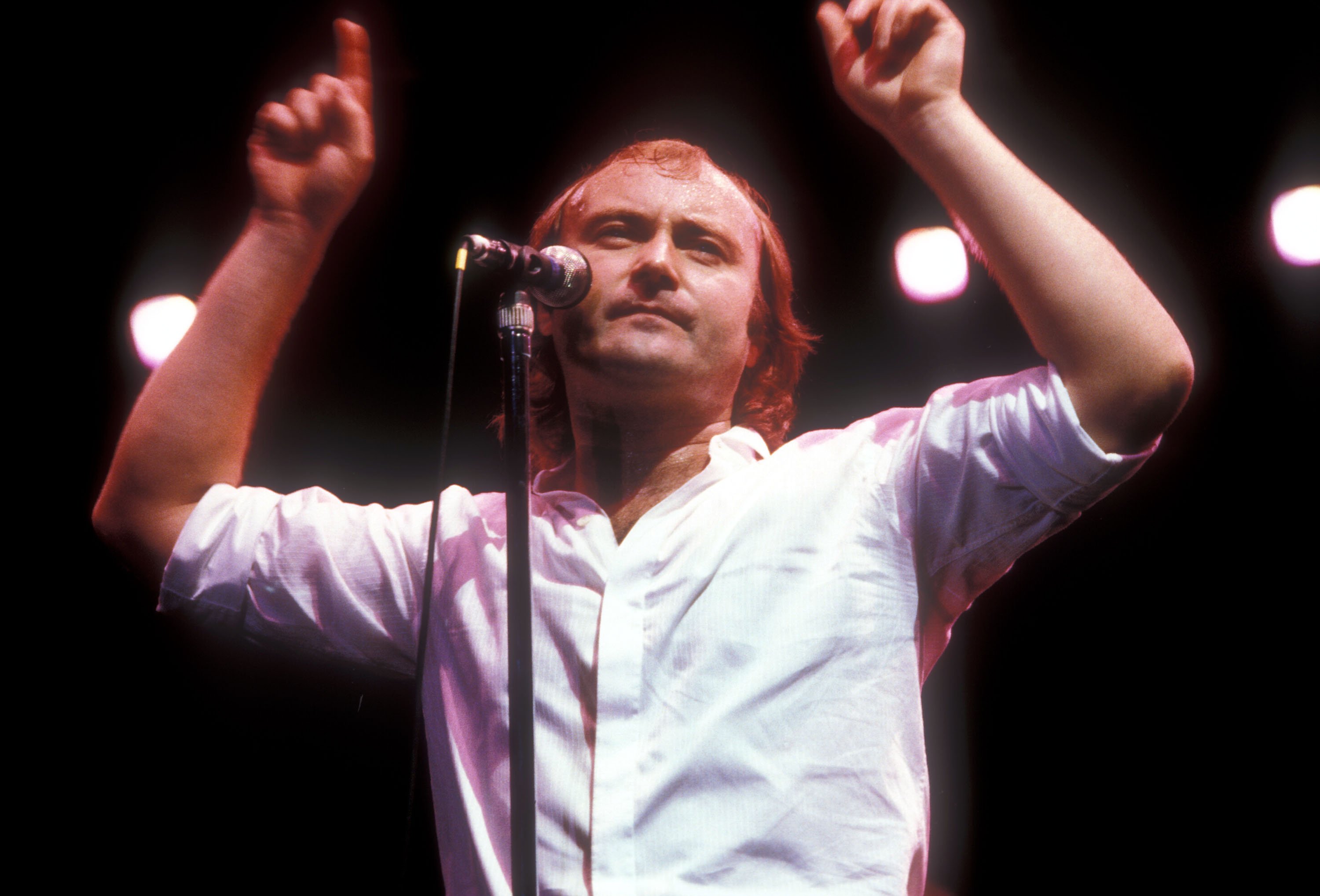 Phil Collins putting his fingers in the air