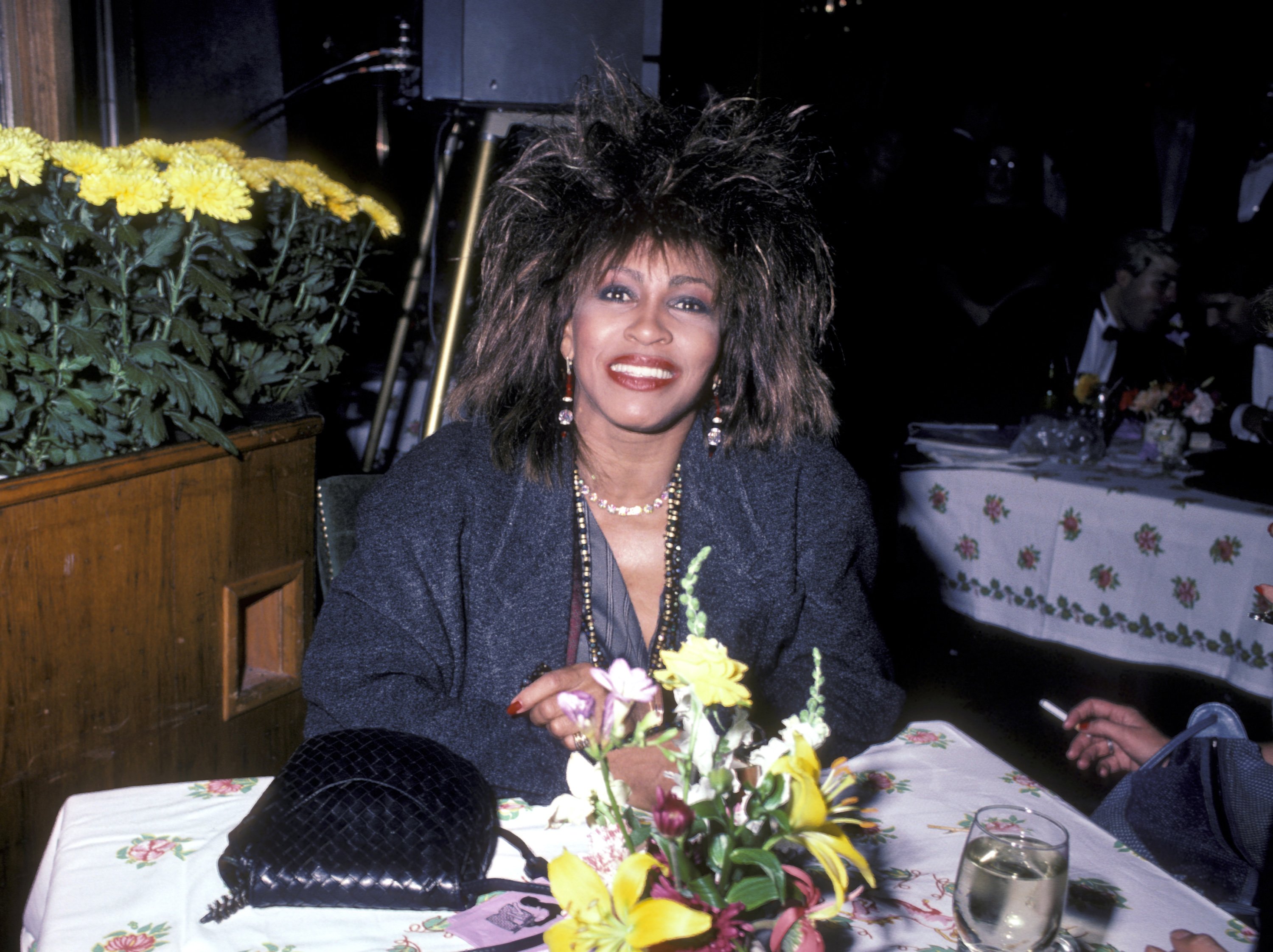 Tina Turner sitting at a table