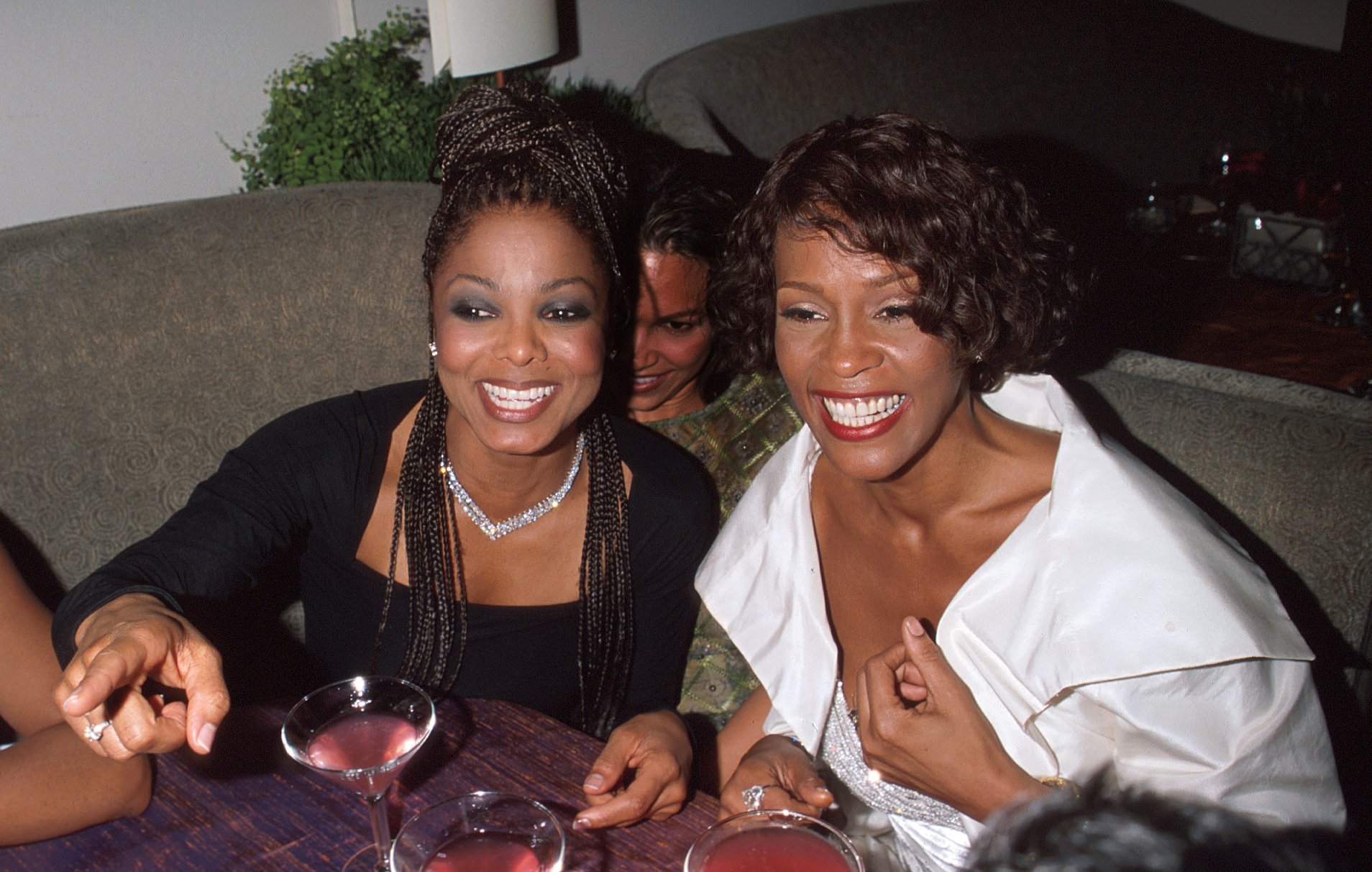 Janet Jackson and Whitney Houston sitting at a table
