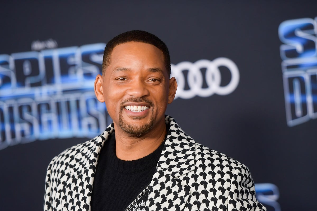 Will Smith smiling in a grey suit.