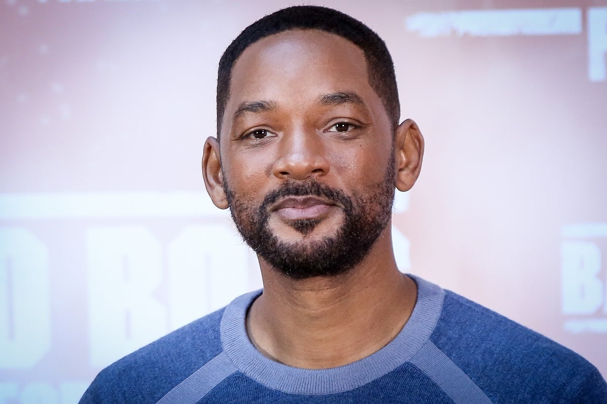 Will Smith smirking while wearing a blue shirt.