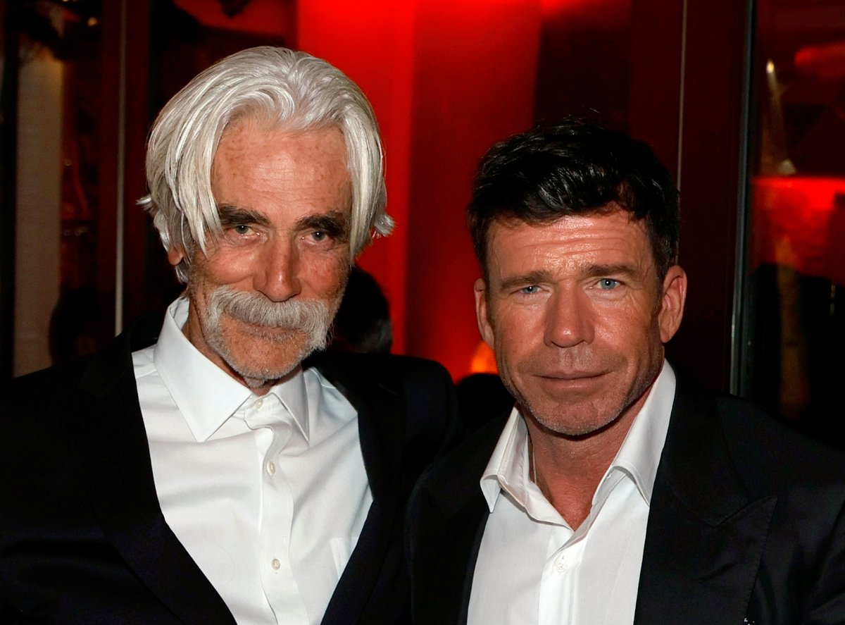 1883 Taylor Sheridan with star Sam Elliott both wearing dark suit jackets at the premiere of the Yellowstone prequel starring Isabel May