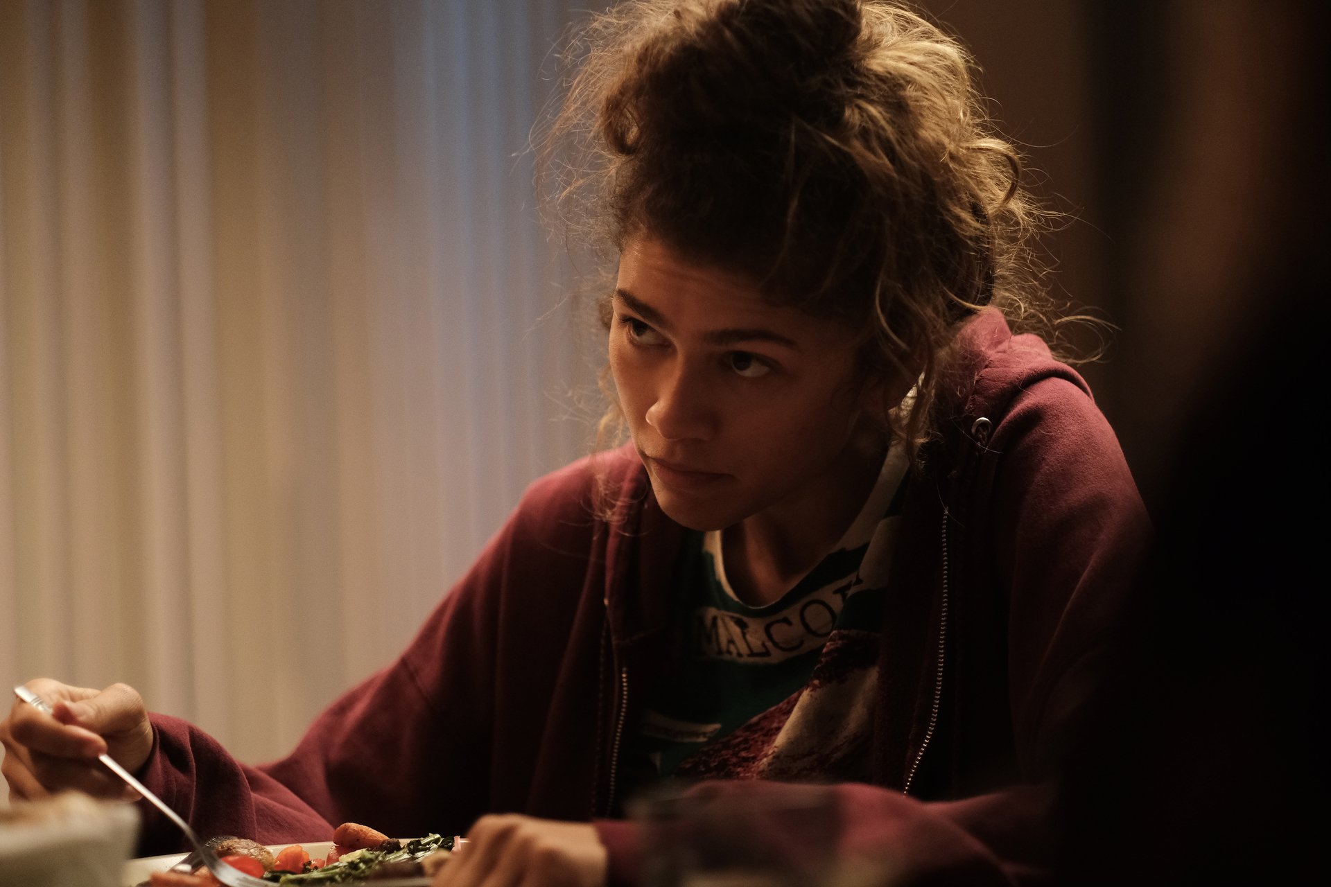 Rue Bennett (Zendaya) sits at the table holding a spoon in 'Euphoria' Season 2, Episode 6